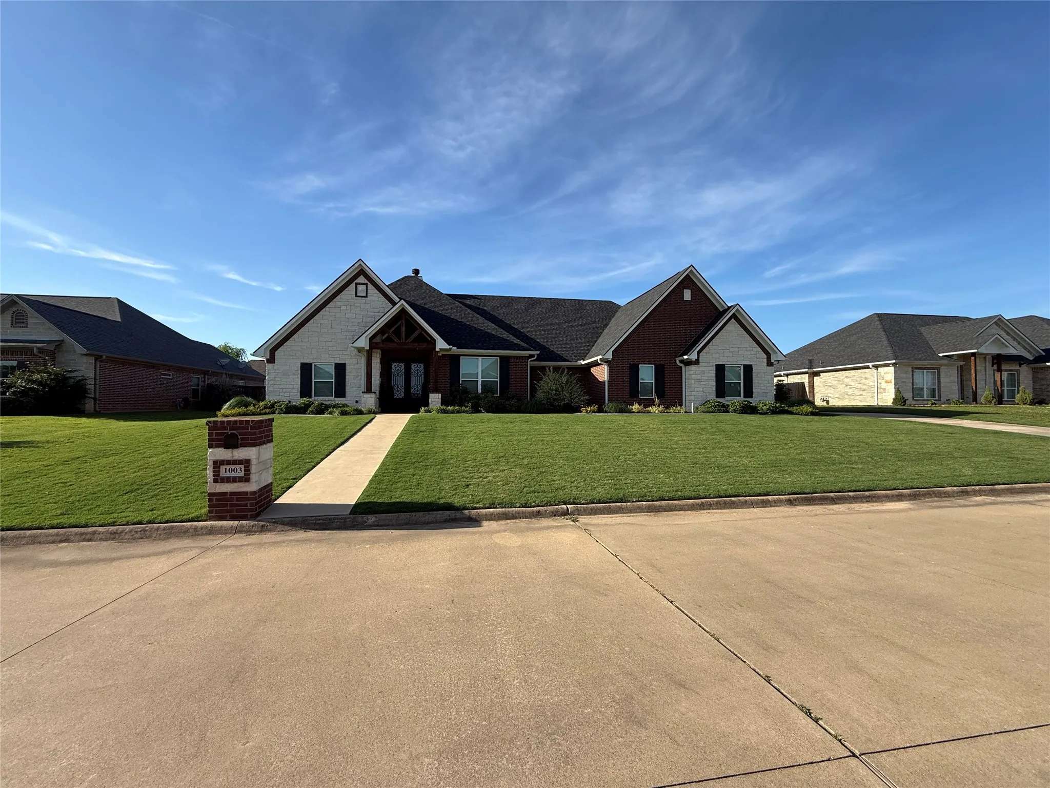 Single story home featuring a front lawn and stone siding