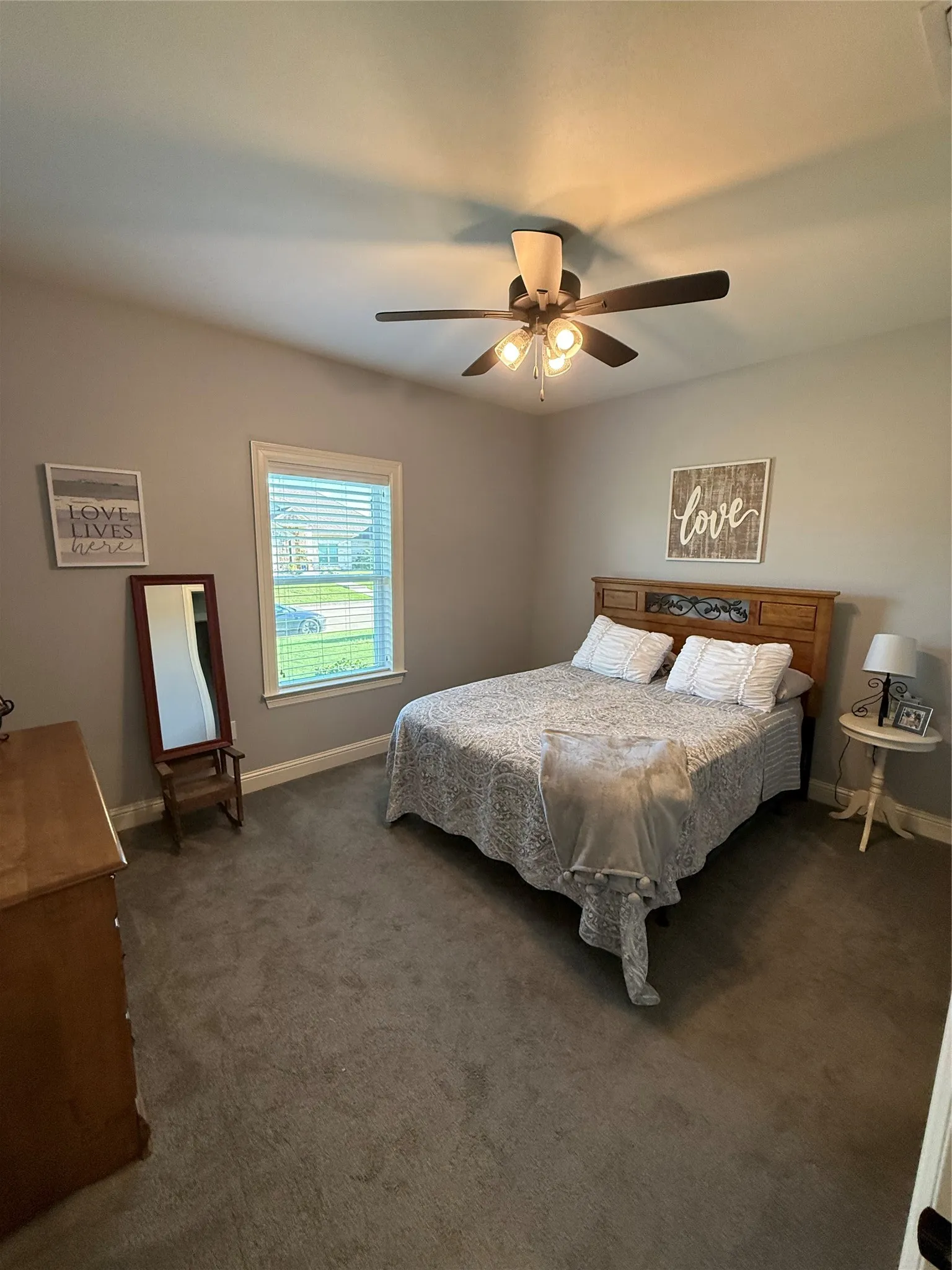 Bedroom featuring dark colored carpet, baseboards, and a ceiling fan