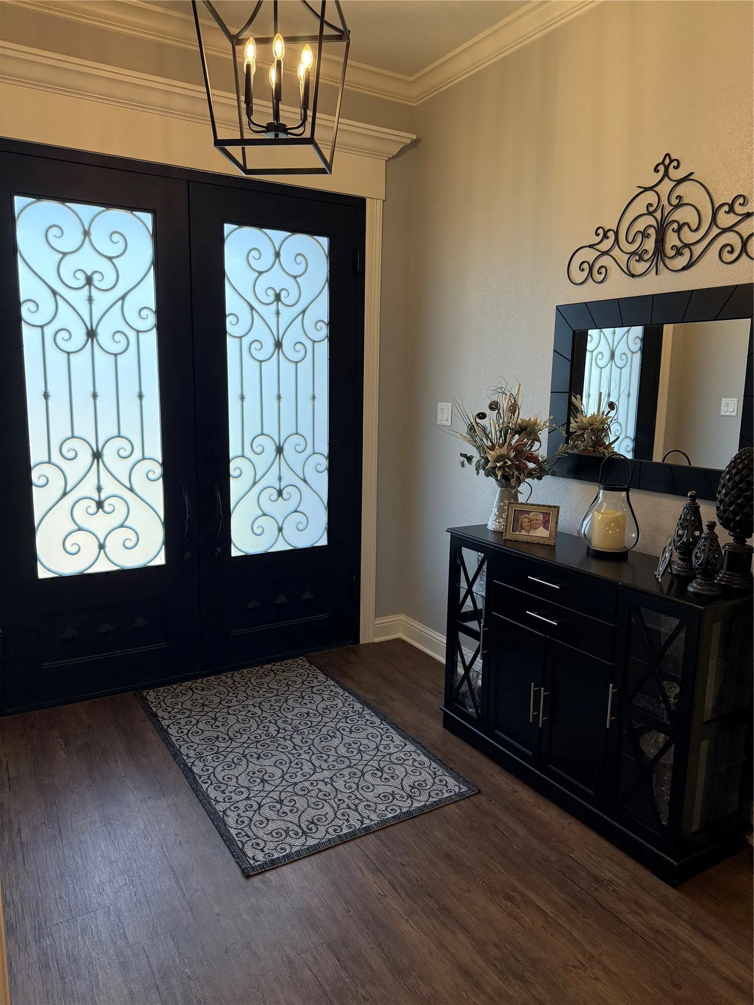 Entrance foyer featuring dark wood-style floors, french doors, a chandelier, crown molding, and baseboards