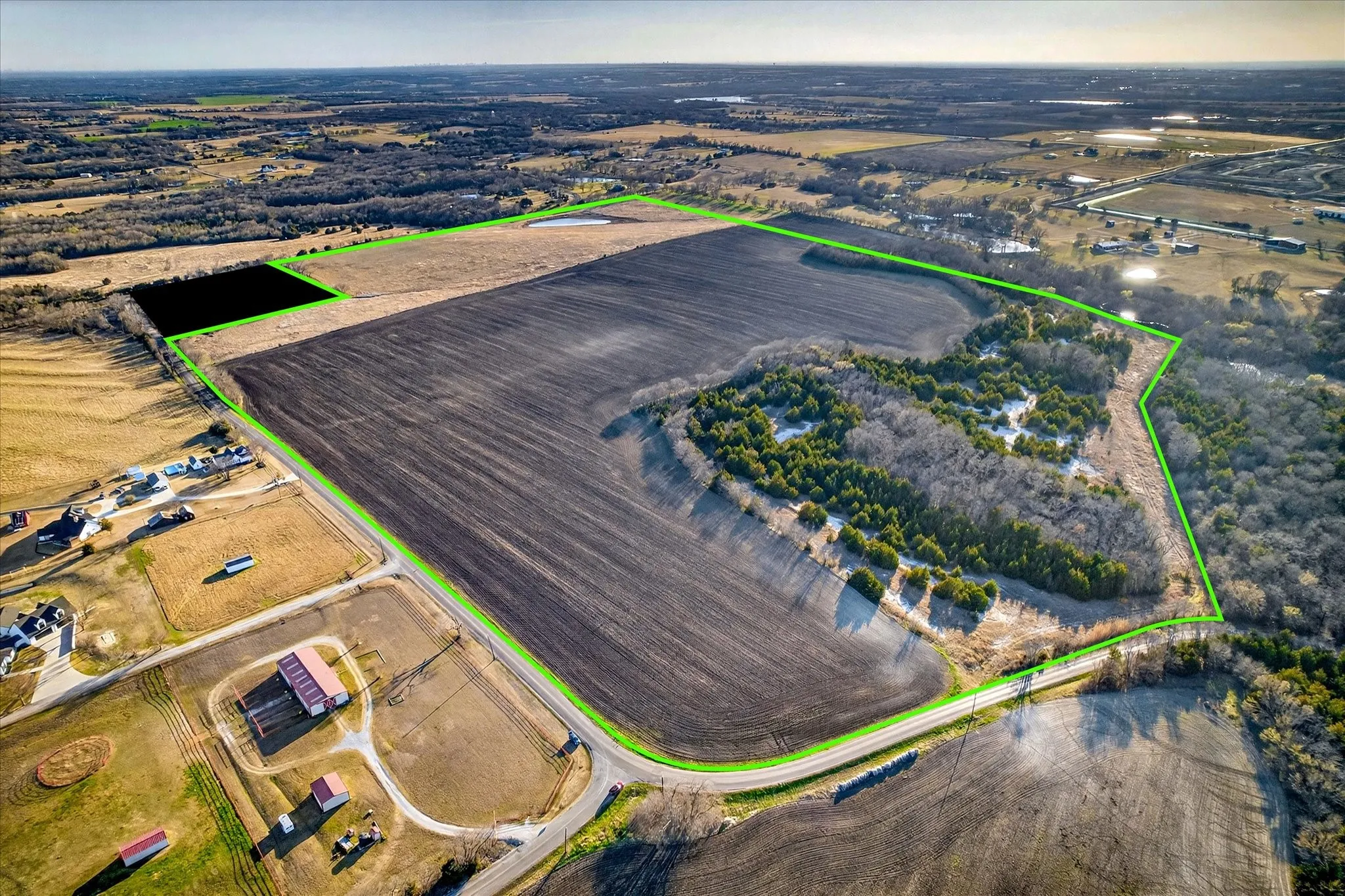 View of the whole tract looking from North to Southwest about 2500 feet frontage on Eden Ridge Rd and 750 feet frontage on FM 455 lovely wooded area on Northwest corner