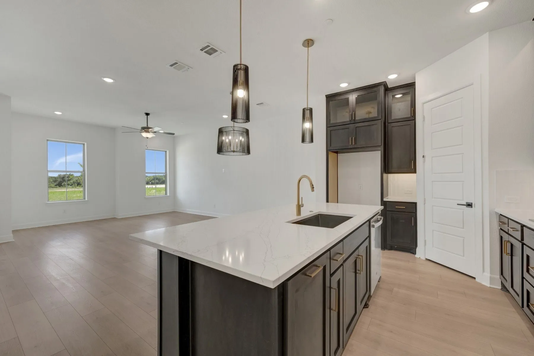 Open-concept kitchen and living area featuring light wood-finish flooring