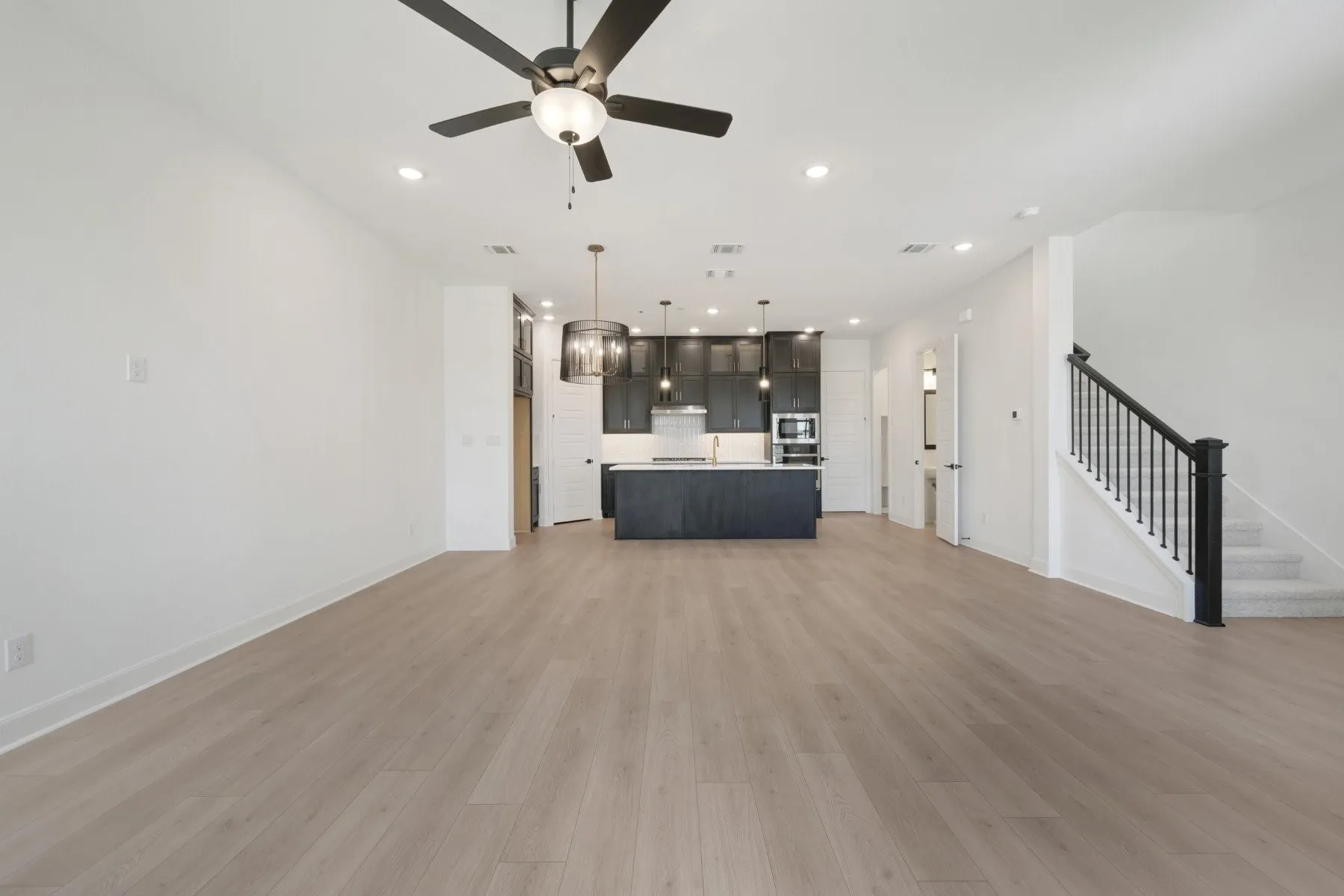 Open-concept living space featuring wood-finish flooring, recessed lighting, and a contemporary ceiling fan