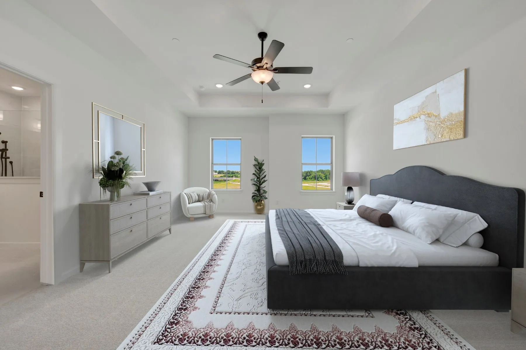 Bedroom featuring light-toned carpeting and a tray ceiling with a ceiling fan