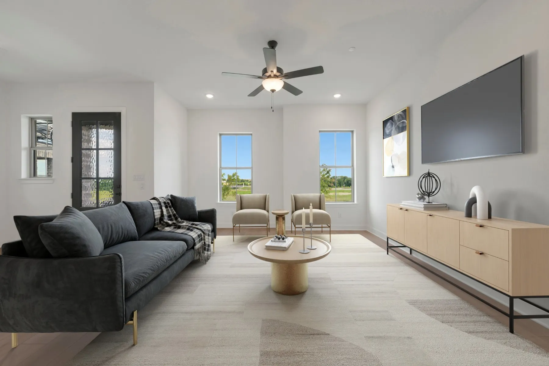 Spacious living area featuring light wood-finish flooring, recessed lighting, and a ceiling fan