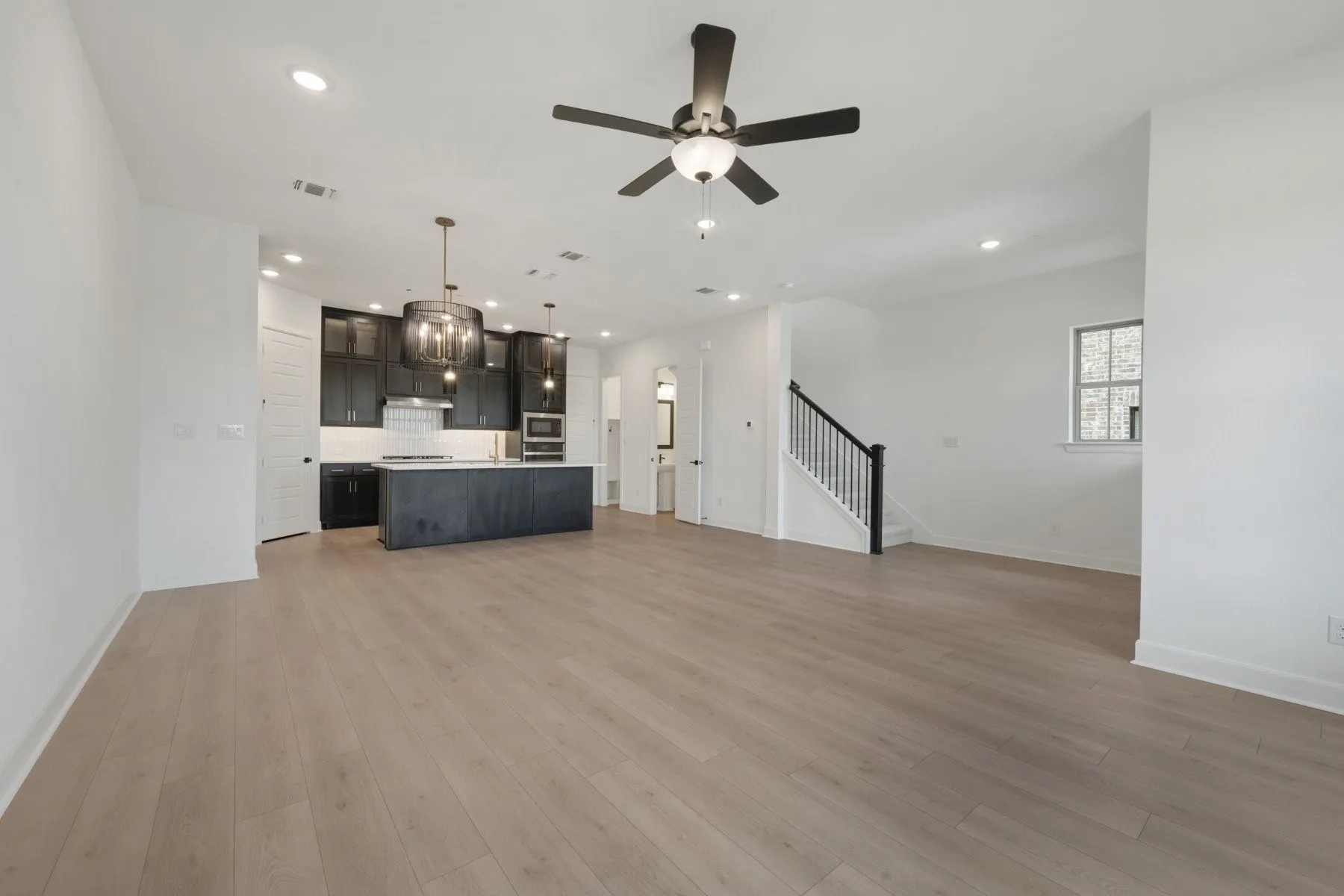 Open-concept living space featuring wood-finish flooring, recessed lighting, and a modern ceiling fan