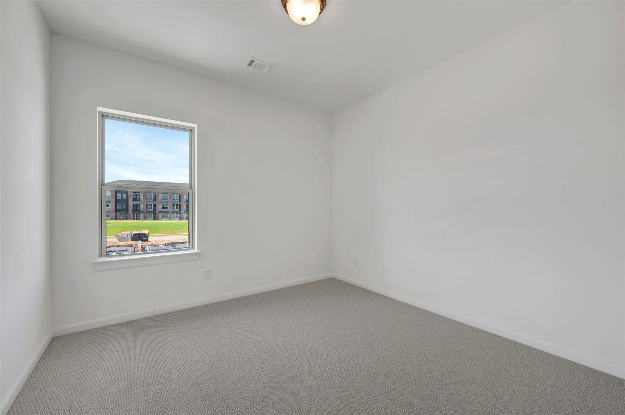 Bright interior room with white walls and gray carpet