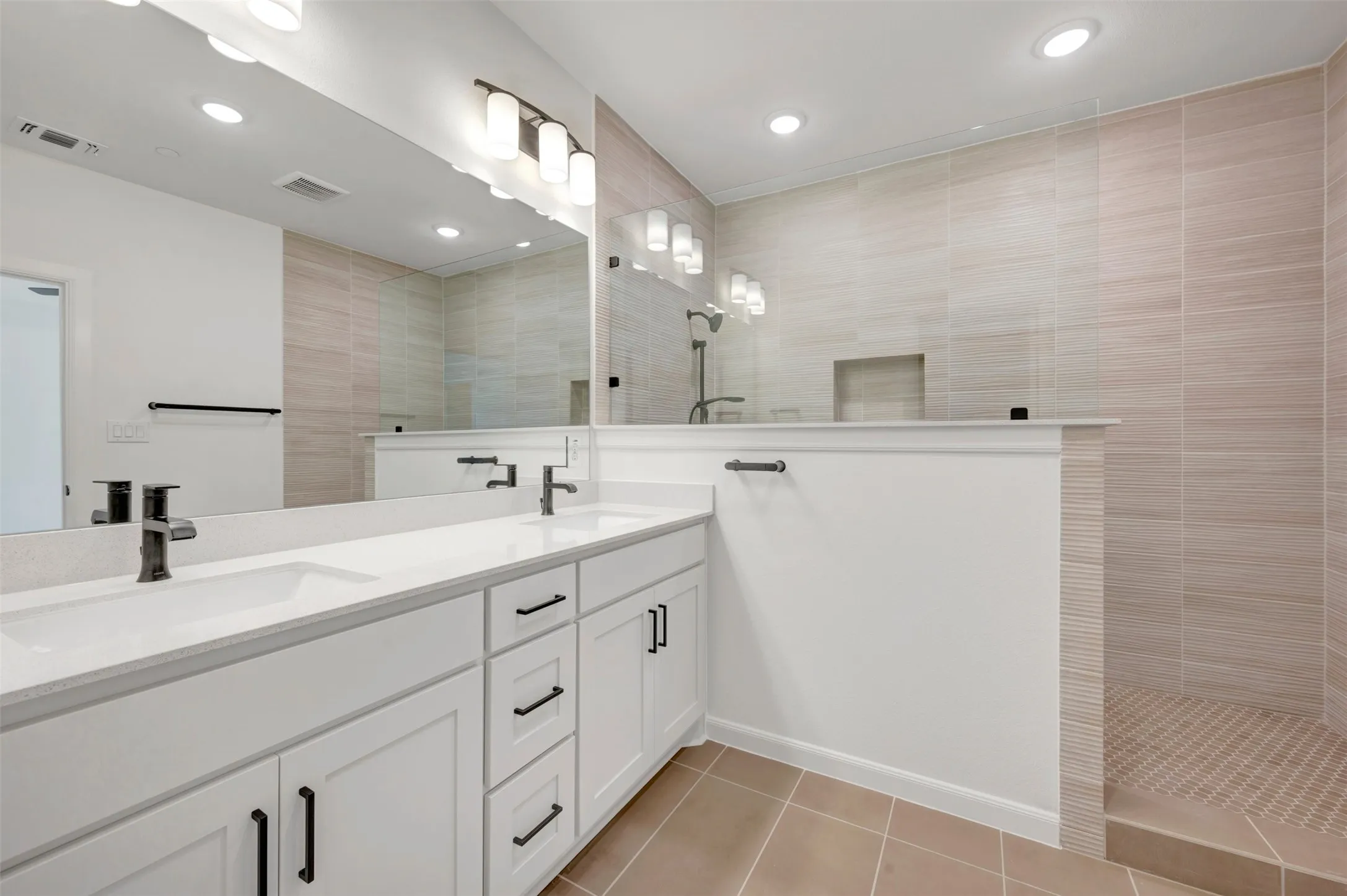 Contemporary bathroom featuring a dual vanity with white cabinetry, quartz countertops, and matte black fixtures