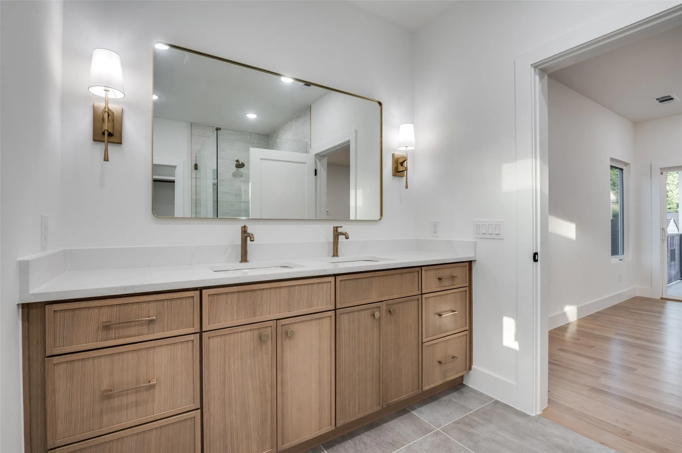 Full bathroom featuring double vanity, a shower stall, wood finished floors, and recessed lighting