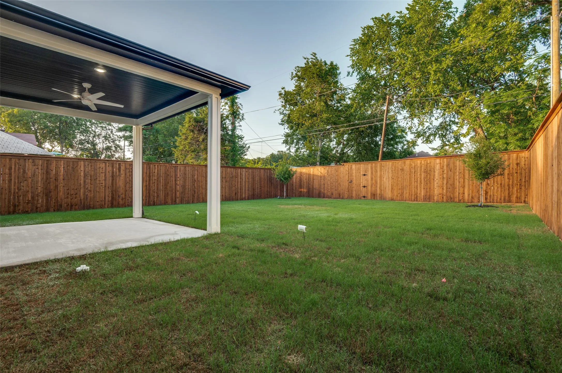 Fenced backyard featuring ceiling fan and a patio area