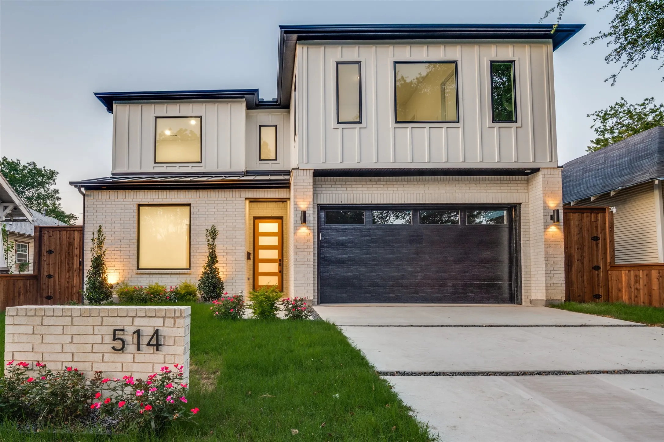 Contemporary house with concrete driveway, brick siding, board and batten siding, and a garage