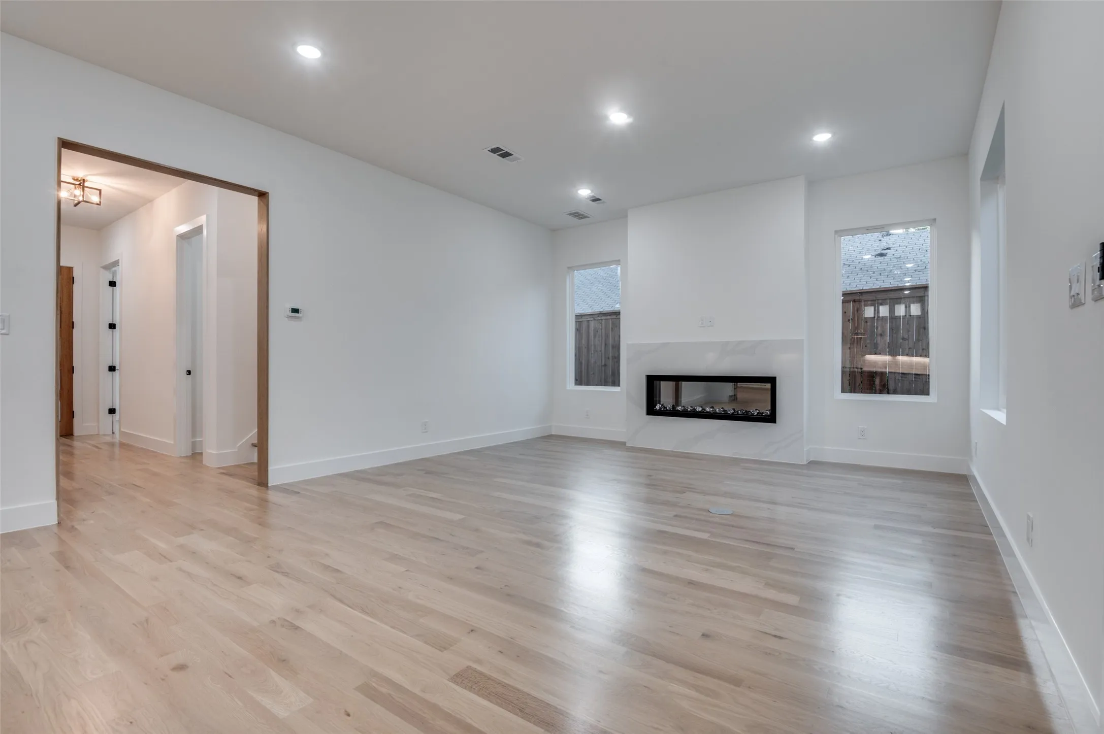 Unfurnished living room with light wood finished floors, a fireplace, and recessed lighting