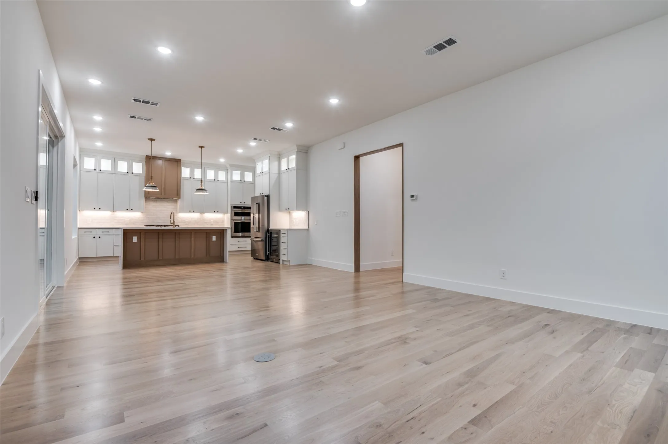 Unfurnished living room with light wood-type flooring and recessed lighting