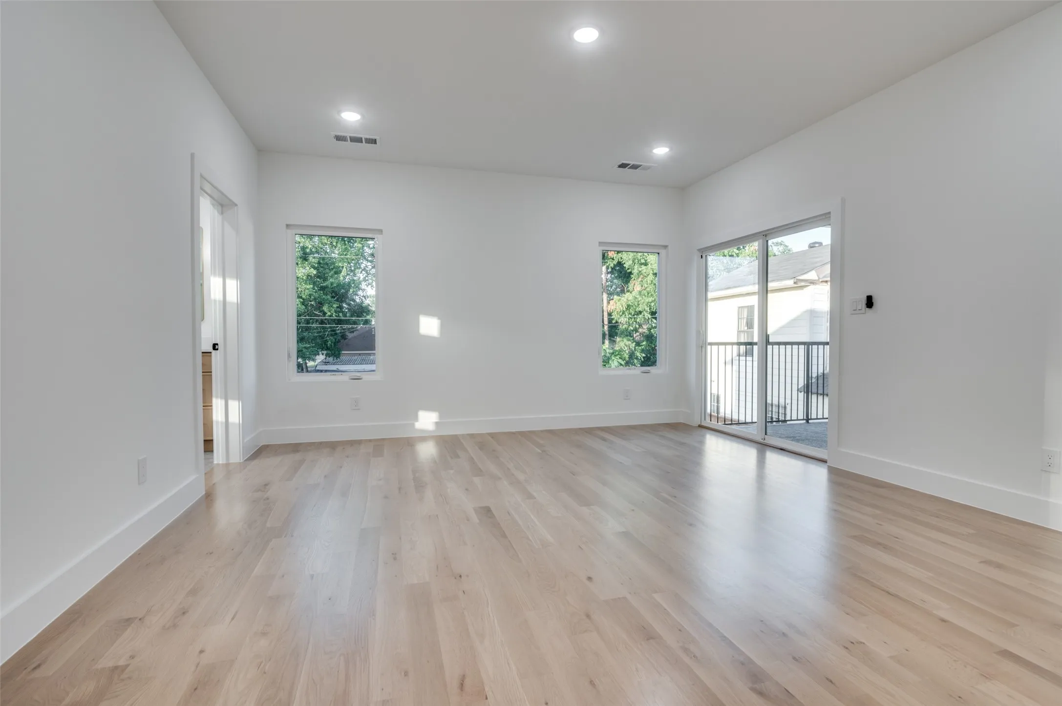Empty room featuring healthy amount of natural light, light wood-style floors, and recessed lighting