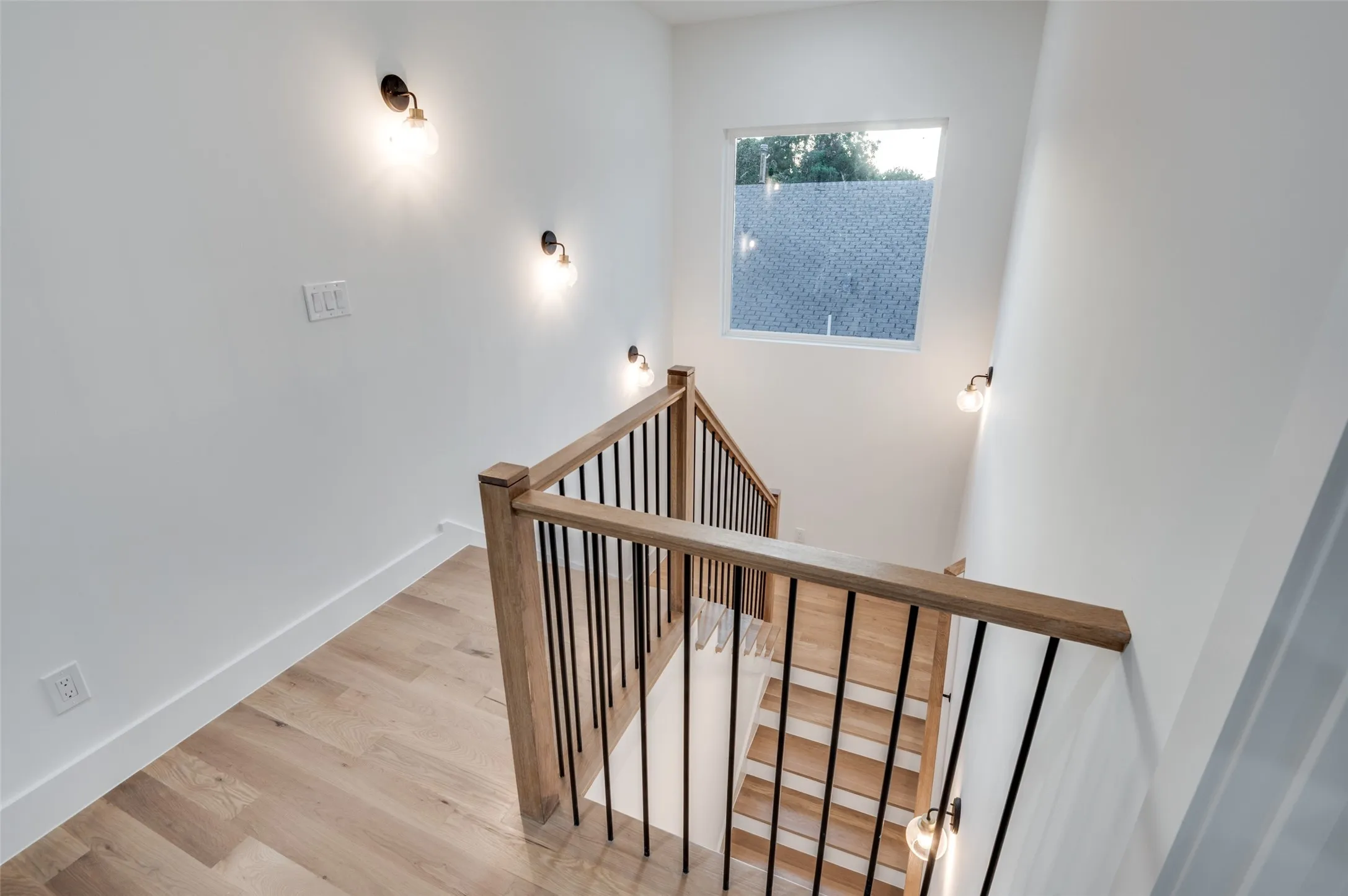 Staircase with wood finished floors and baseboards