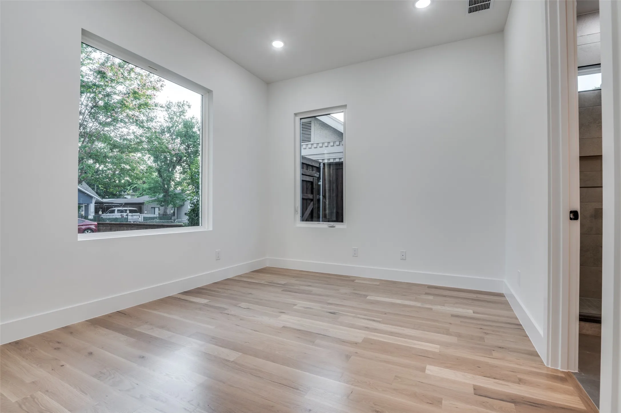 Empty room featuring light wood finished floors and recessed lighting