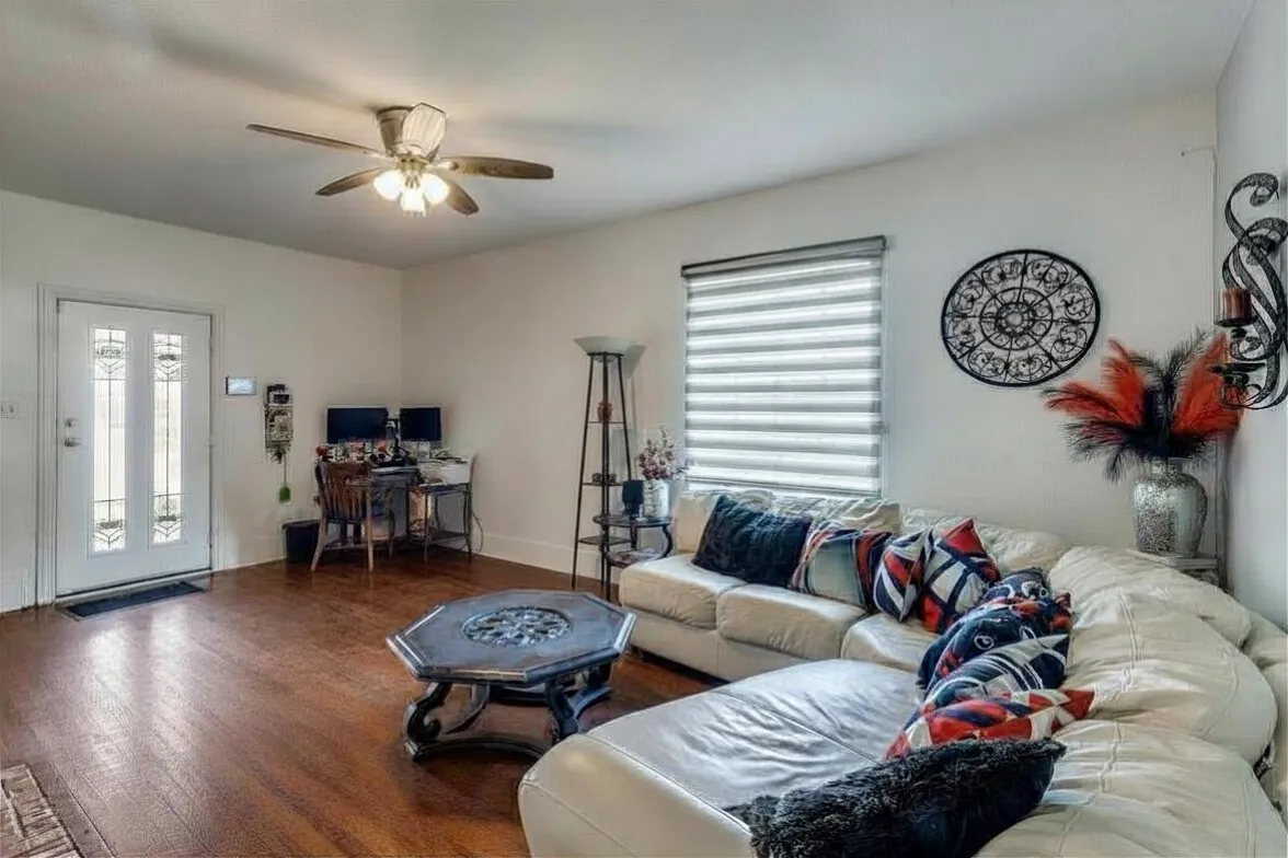Living area featuring wood finished floors, a ceiling fan, and an office area
