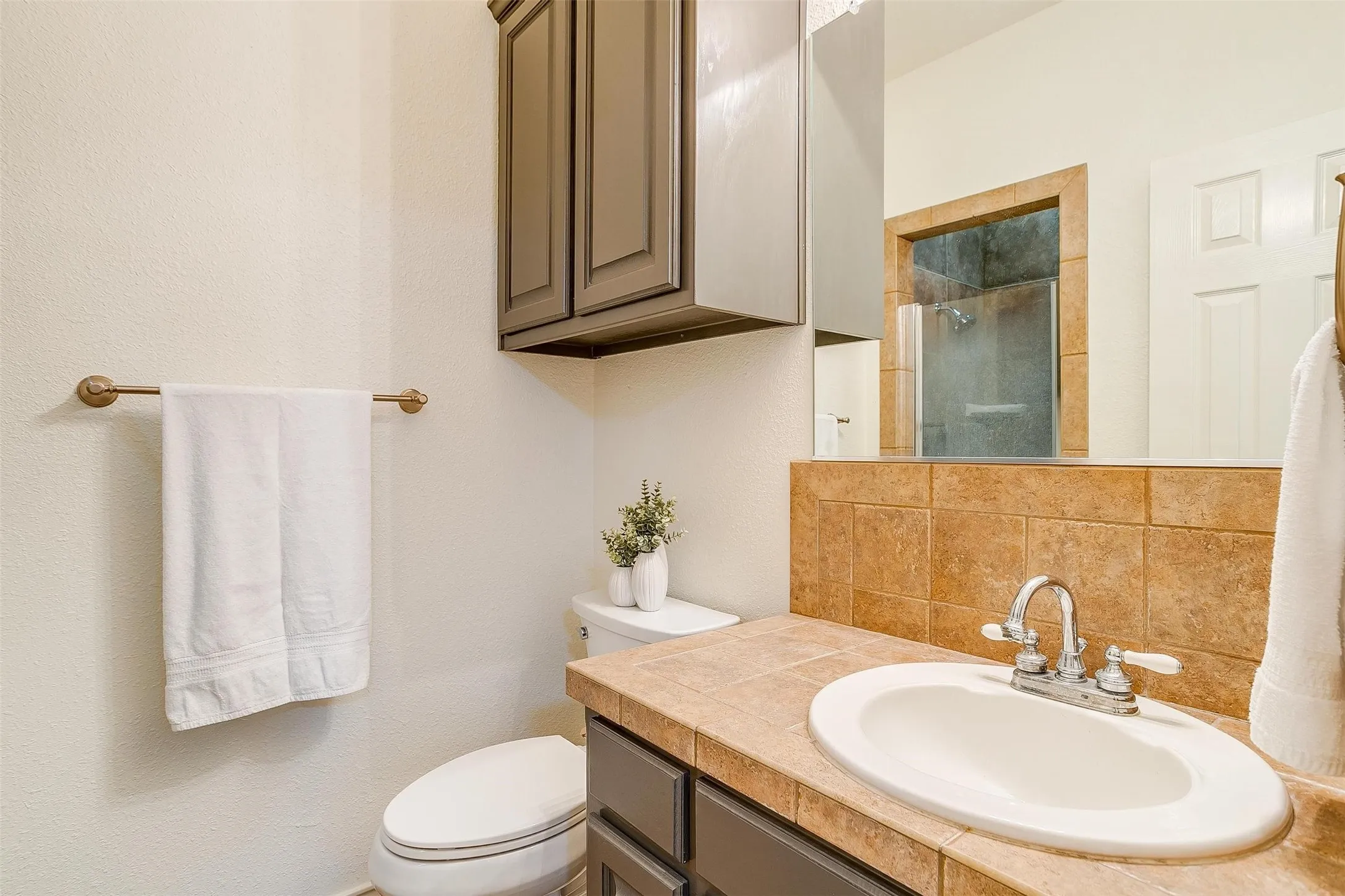 Full bathroom with tasteful backsplash, vanity, and tiled shower