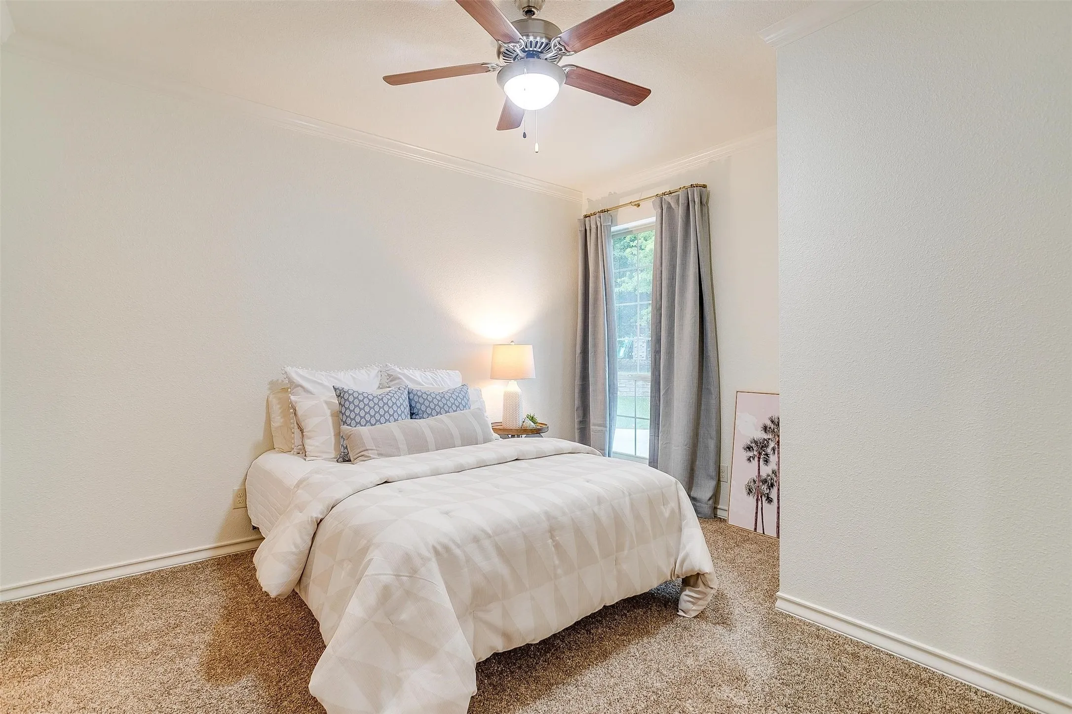 Bedroom featuring carpet floors, crown molding, and a ceiling fan