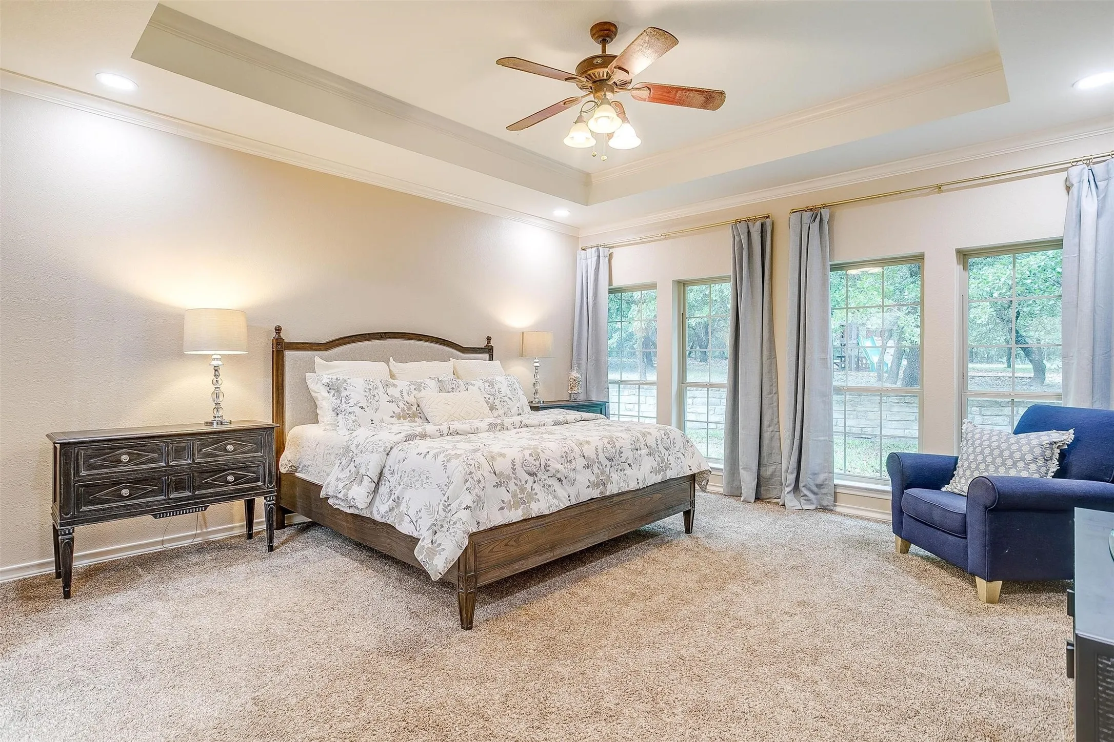 Bedroom featuring light colored carpet, crown molding, ceiling fan, a raised ceiling, and recessed lighting