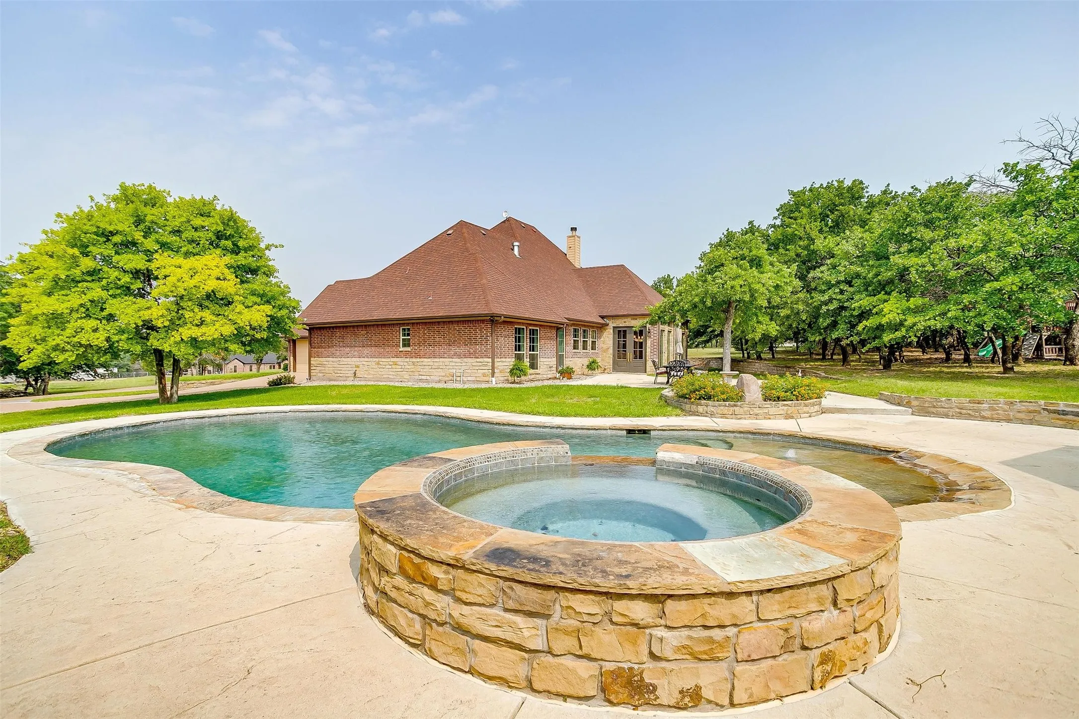 Relaxing pool / spa with a yard and a patio area