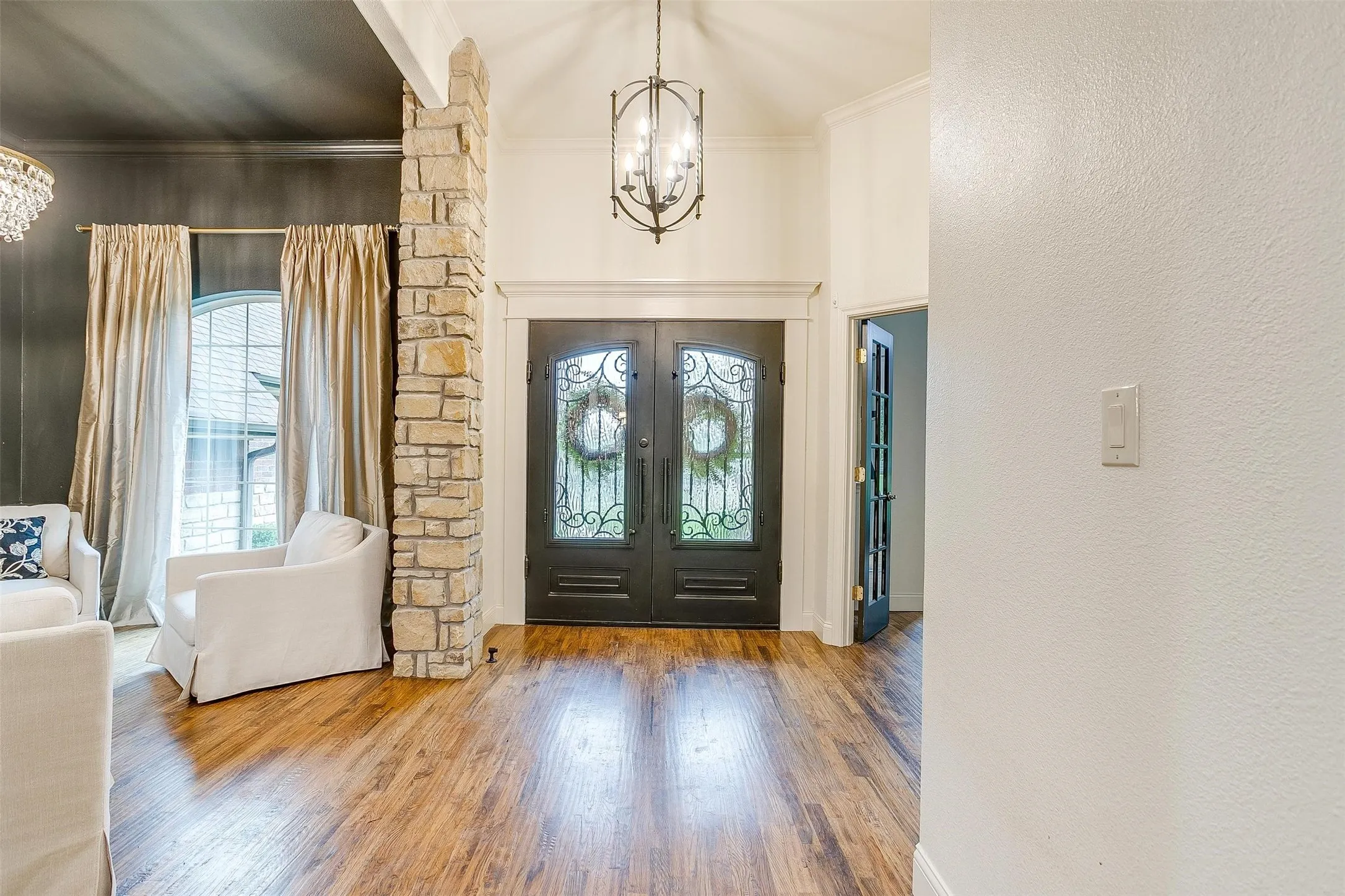 Foyer featuring suspended lighting, ornamental molding, wood finished floors, french doors, and plenty of natural light