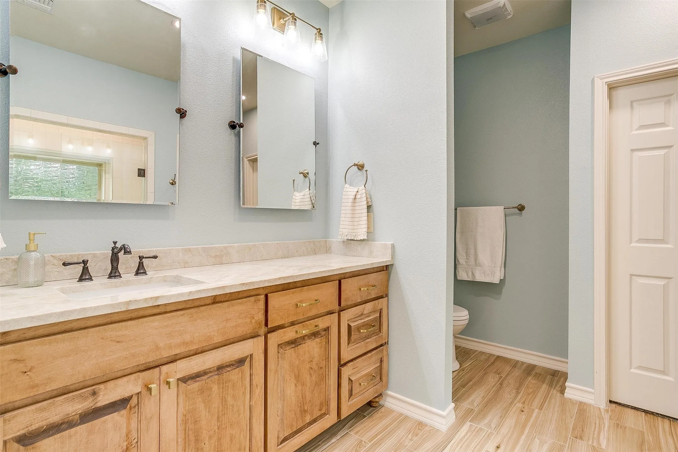 Bathroom featuring vanity and light wood-style floors