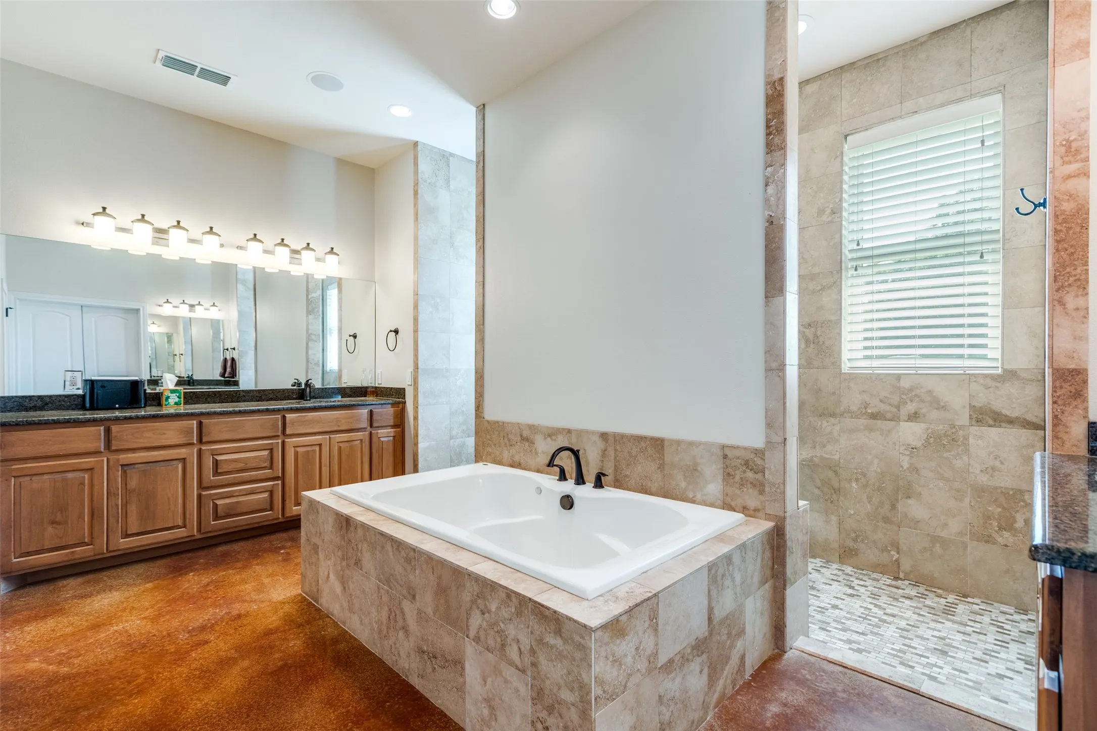 Bathroom with a garden tub, double vanity, a walk in shower, recessed lighting, and finished concrete floors