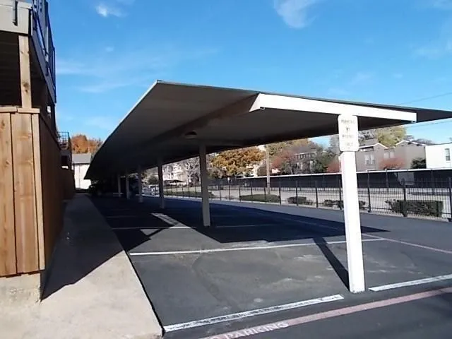 Parking space in front of fenced patio