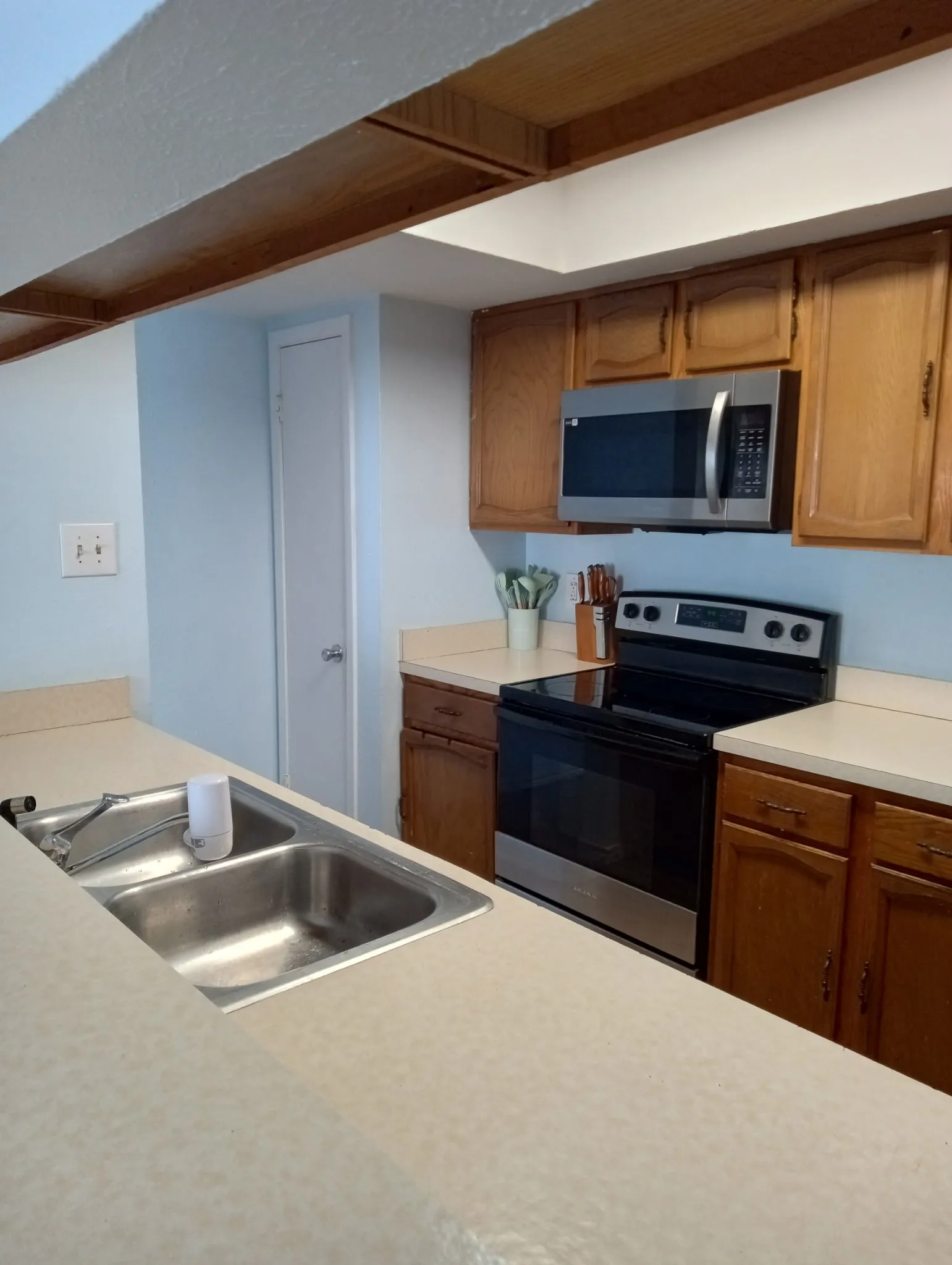 Kitchen with light countertops, stainless steel appliances, and wood finish cabinets