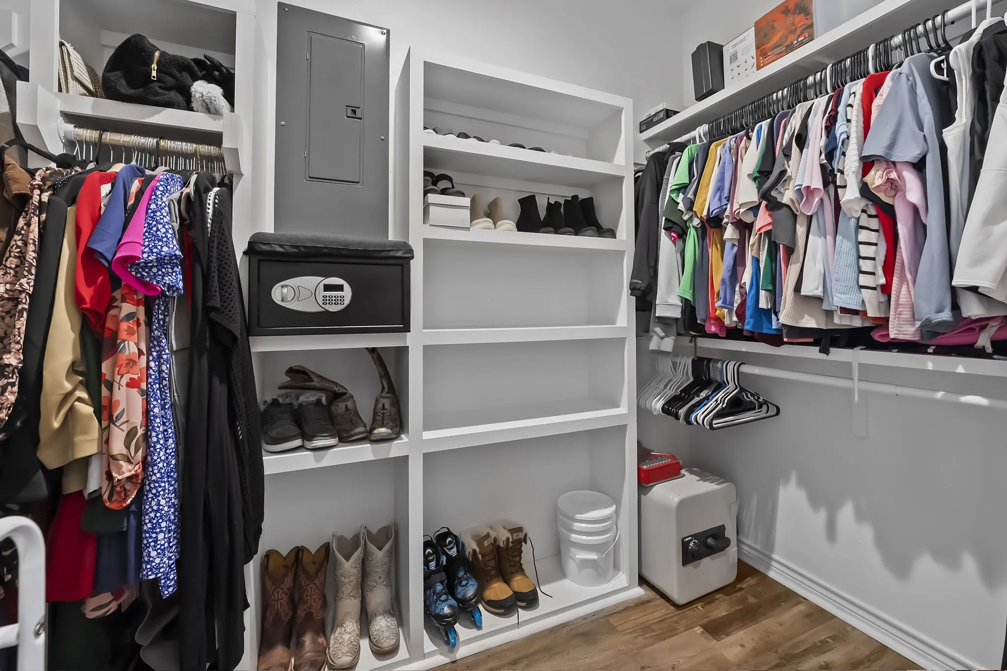 Walk in closet with electric panel and light wood-type flooring