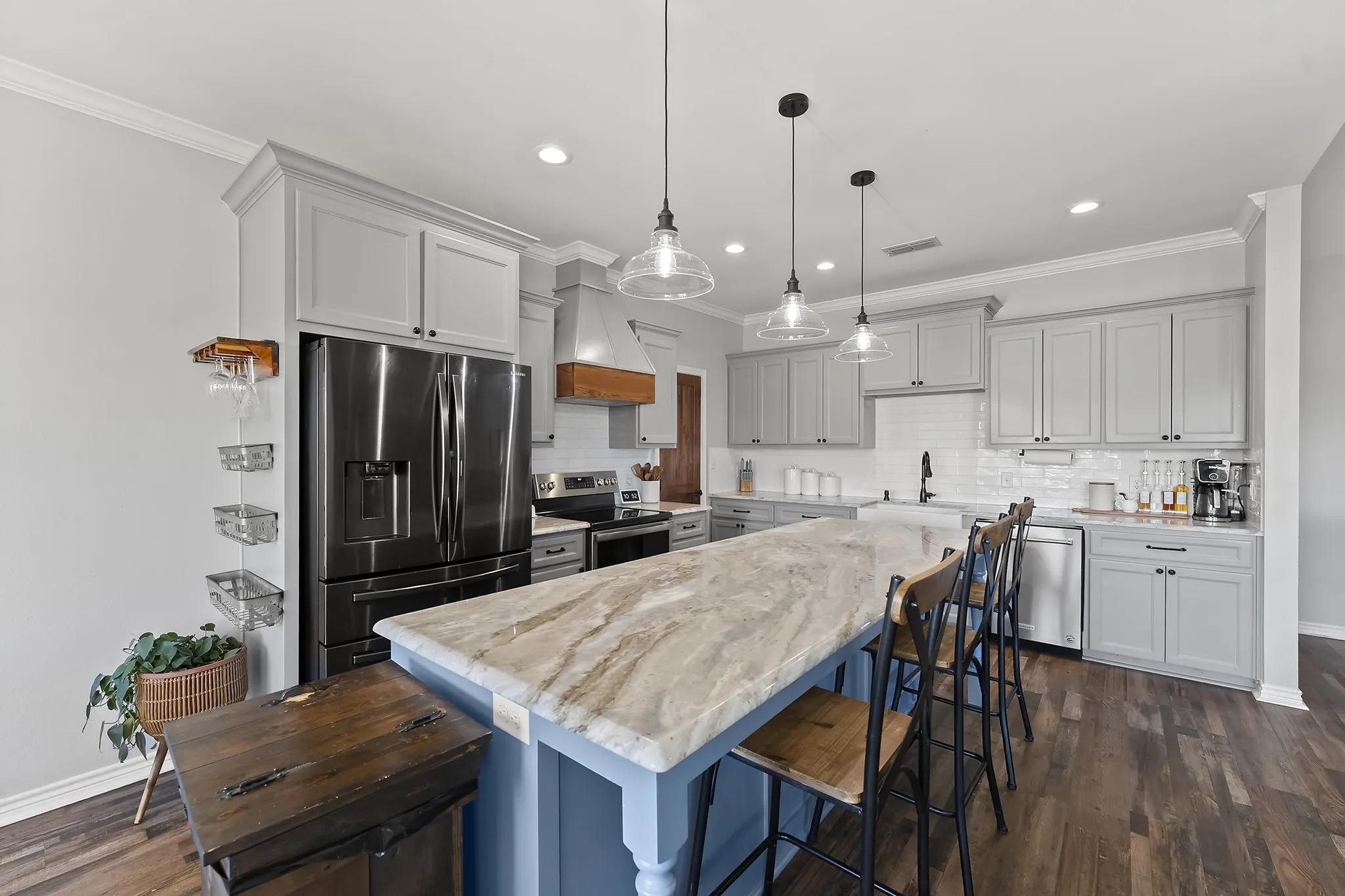 Kitchen with a breakfast bar area, stainless steel appliances, dark wood-type flooring, ornamental molding, and tasteful backsplash
