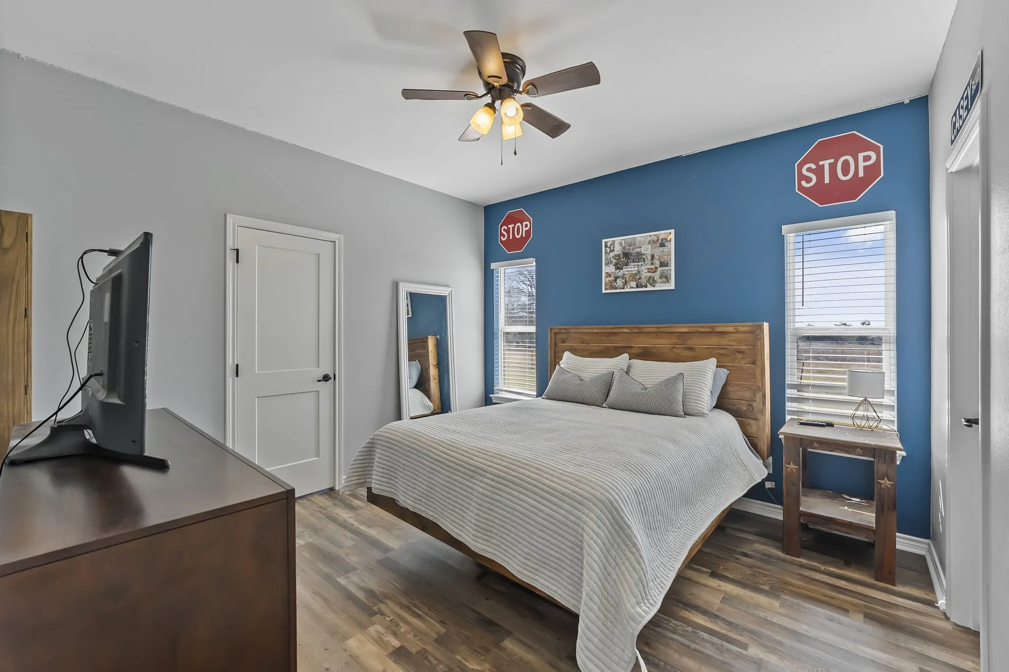 Bedroom with multiple windows, dark wood finished floors, and a ceiling fan