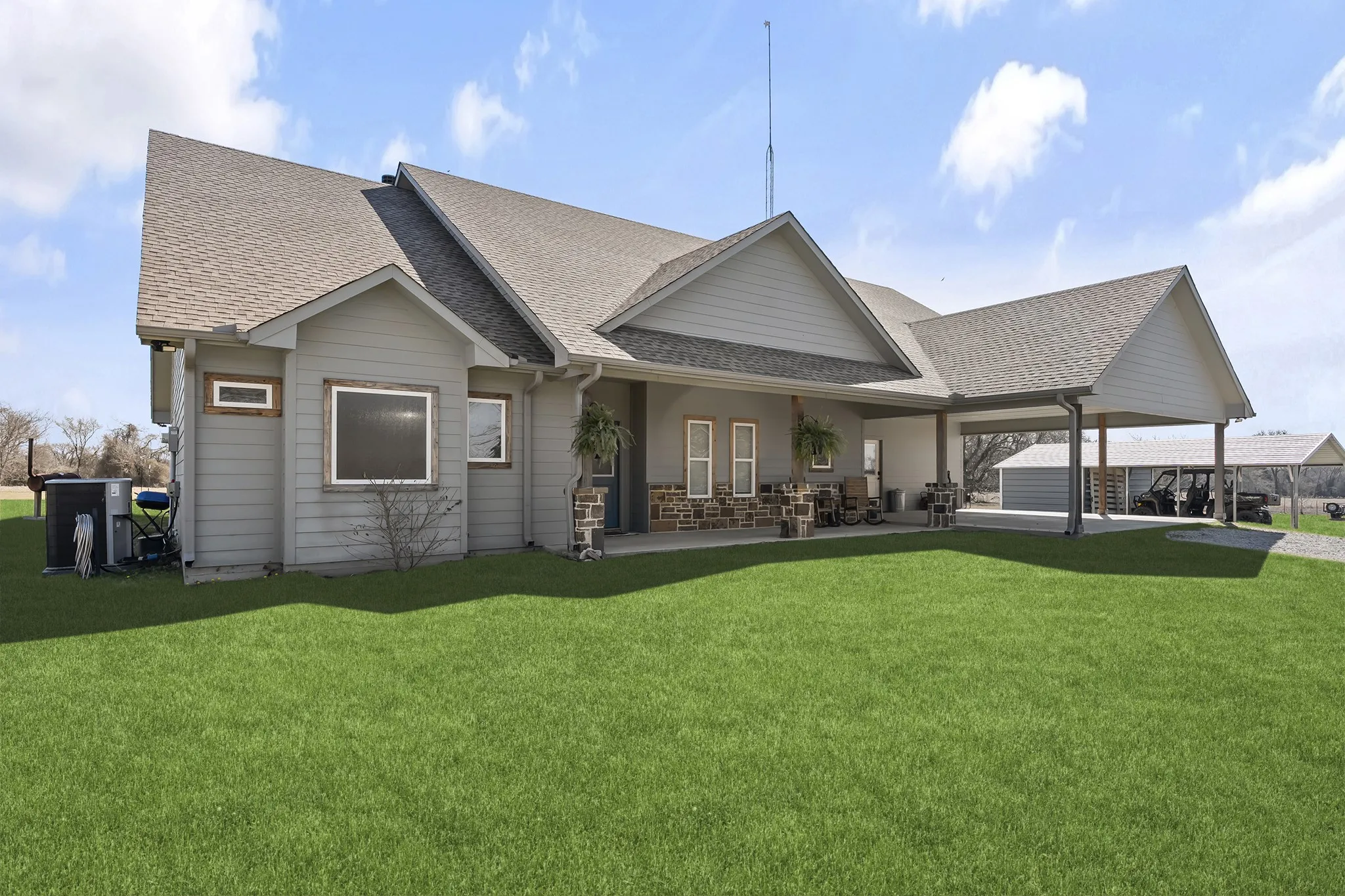 Rear view of house with a shingled roof, a lawn, and a patio