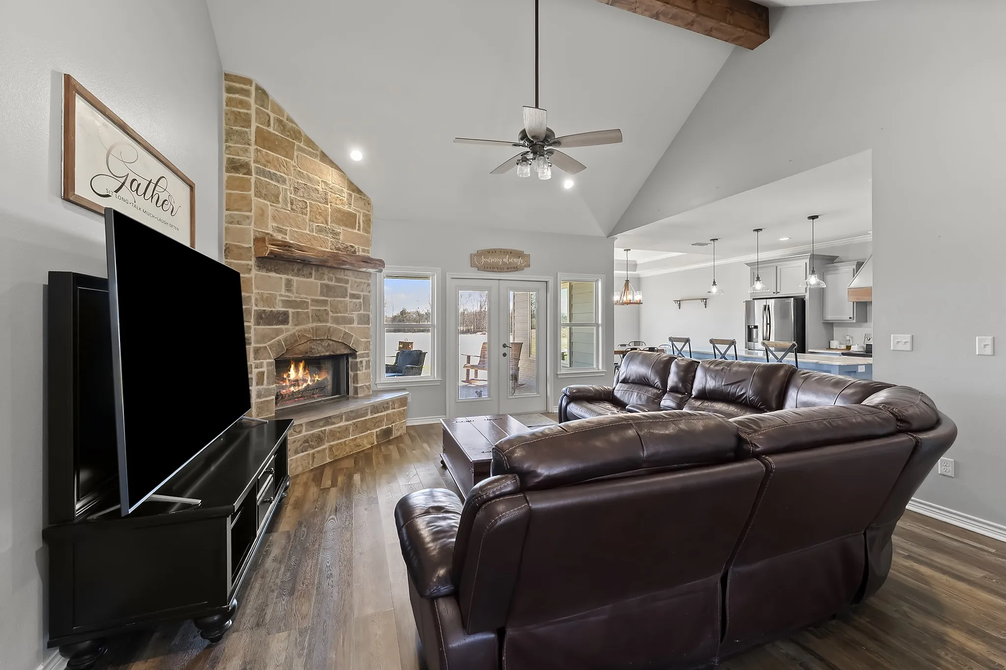 Living area featuring a fireplace, dark wood finished floors, vaulted ceiling, a ceiling fan, and recessed lighting