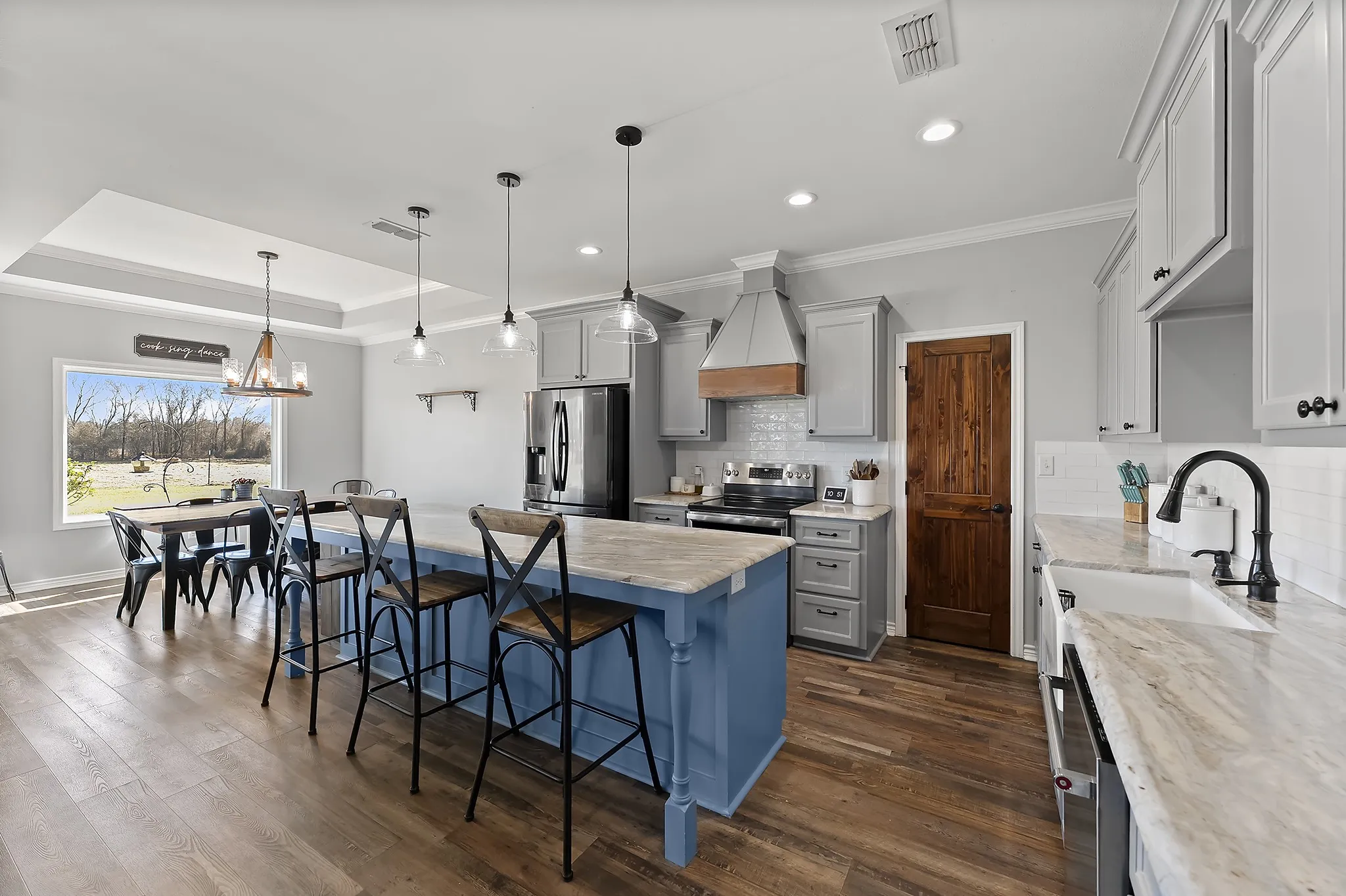 Kitchen with a kitchen bar, stainless steel appliances, a center island, tasteful backsplash, and dark wood-type flooring