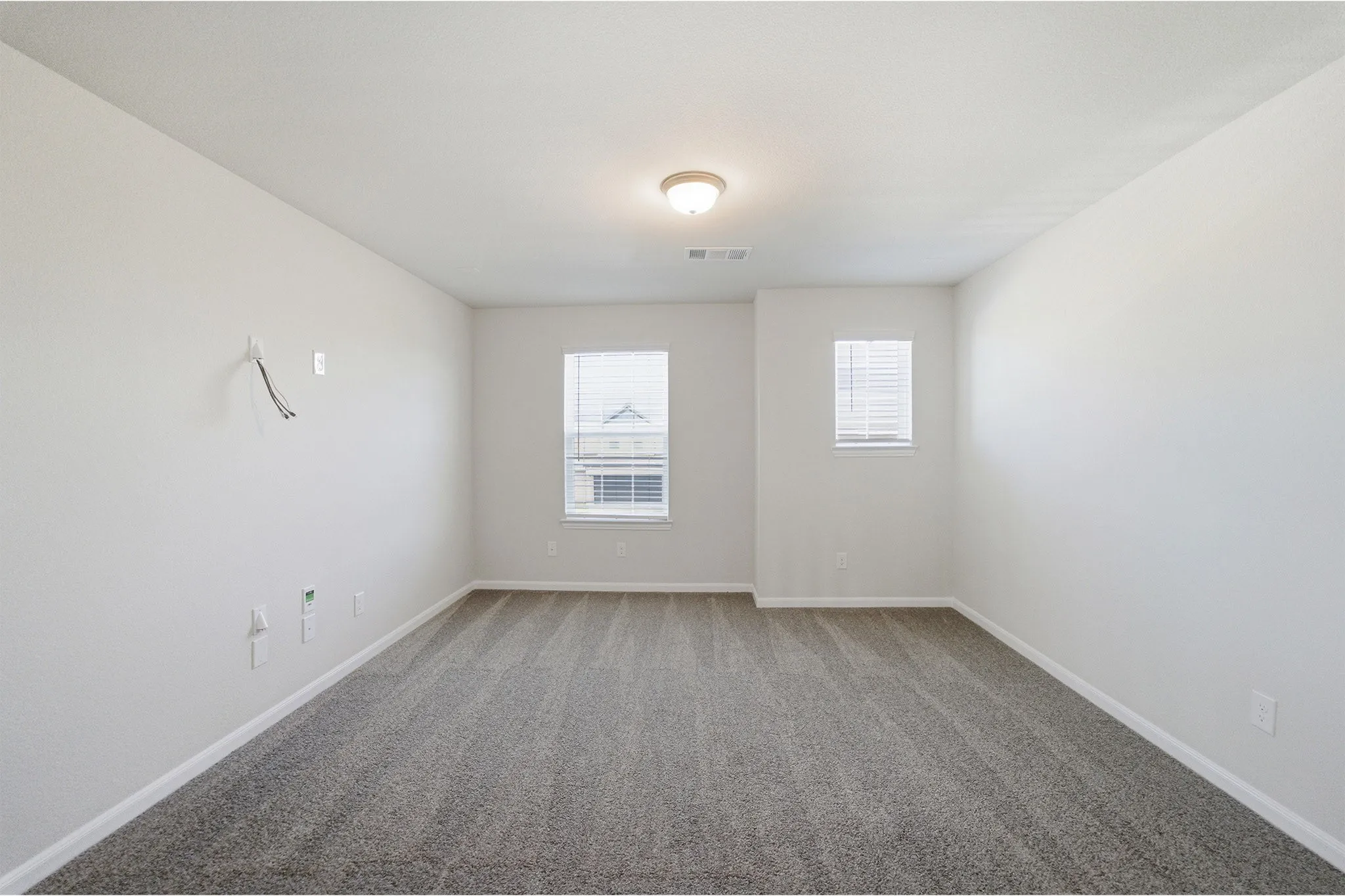 Carpeted interior space with neutral wall tones and a flush-mount ceiling light