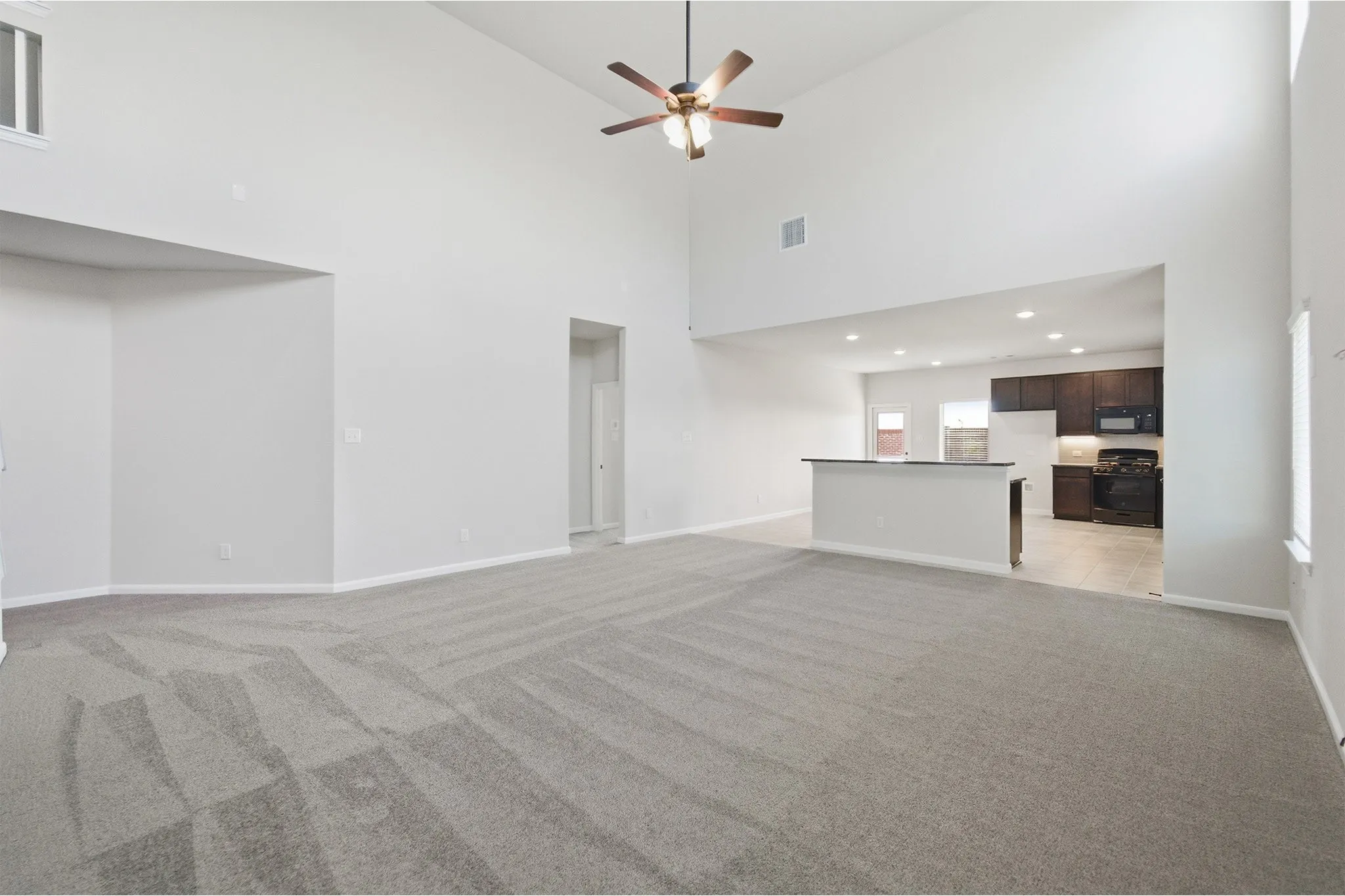 Open concept living area with vaulted ceilings and a ceiling fan