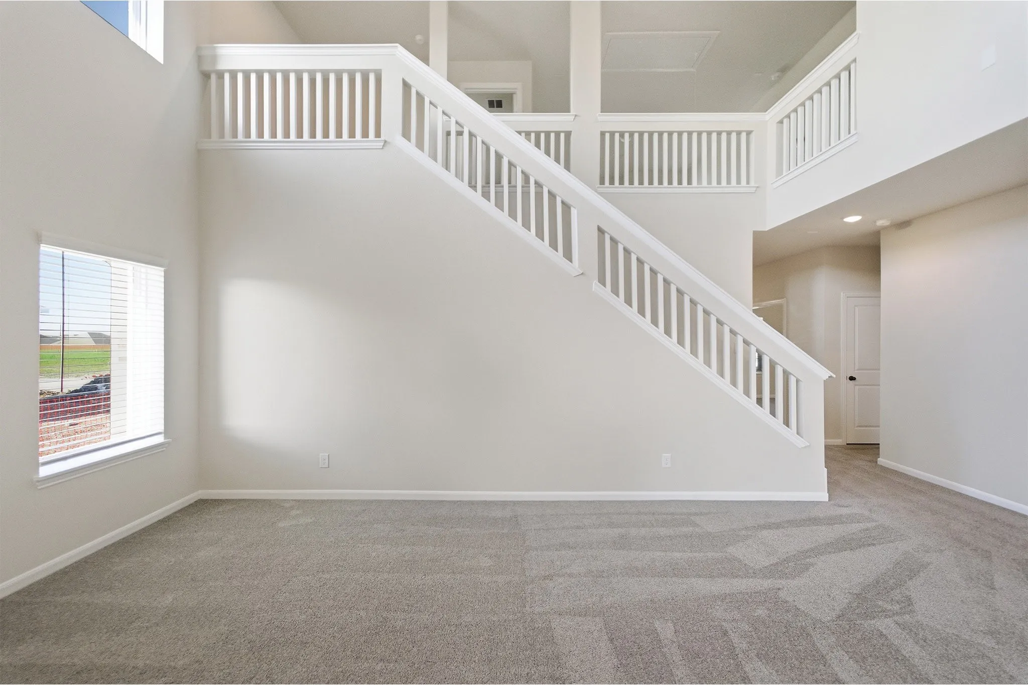 Grand entryway featuring a prominent staircase with white balusters and handrails