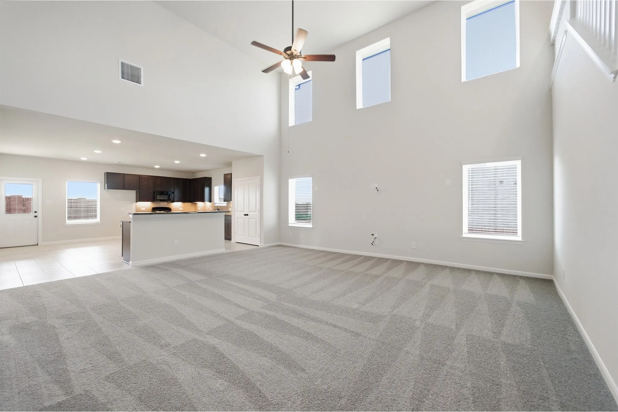 Spacious living area featuring a vaulted ceiling and geometric pattern carpeting