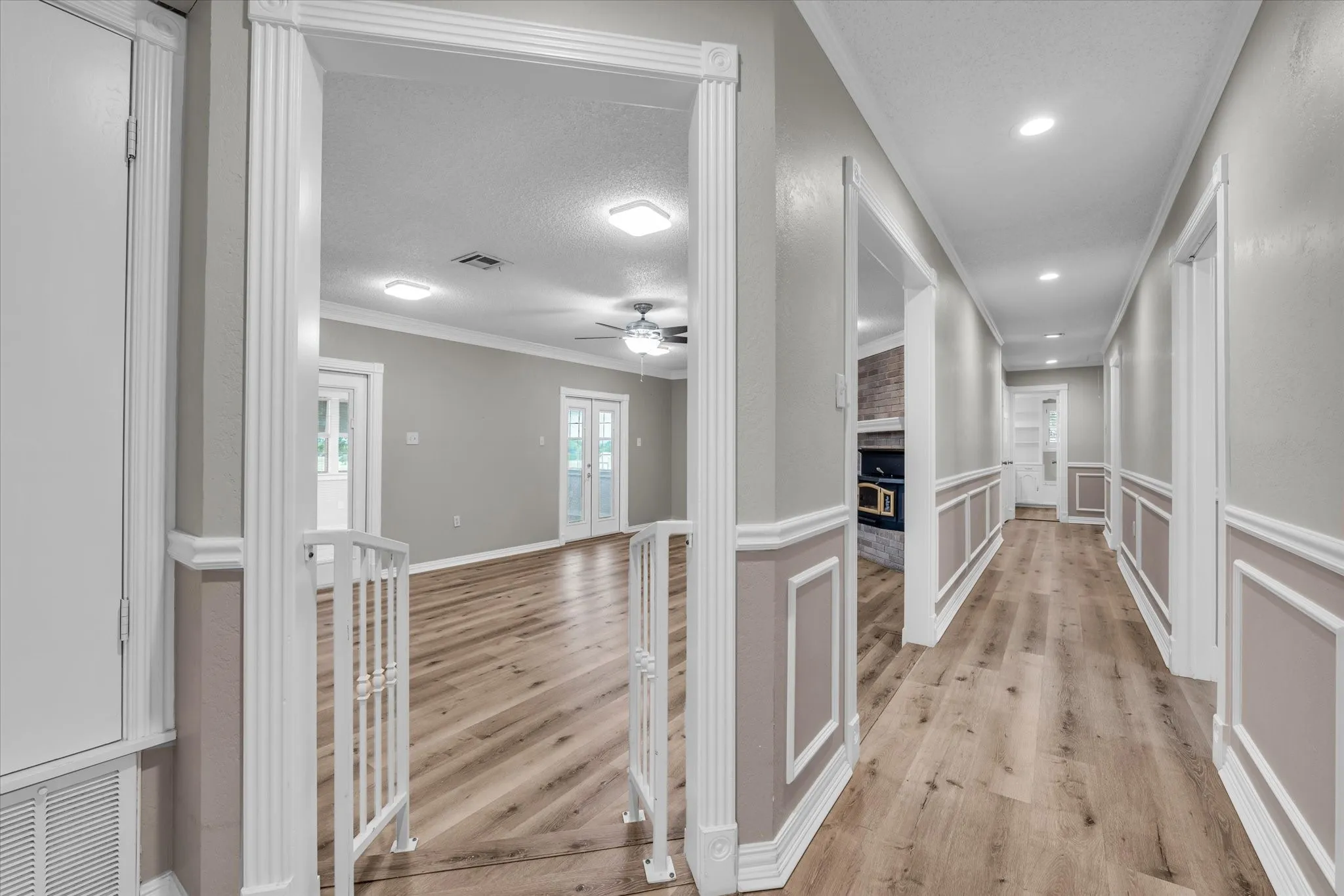 Corridor featuring light wood-style flooring, ornamental molding, and recessed lighting