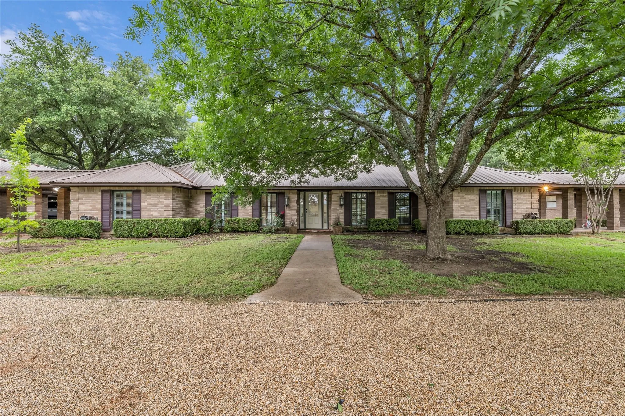 Ranch-style home with a metal roof and a front yard
