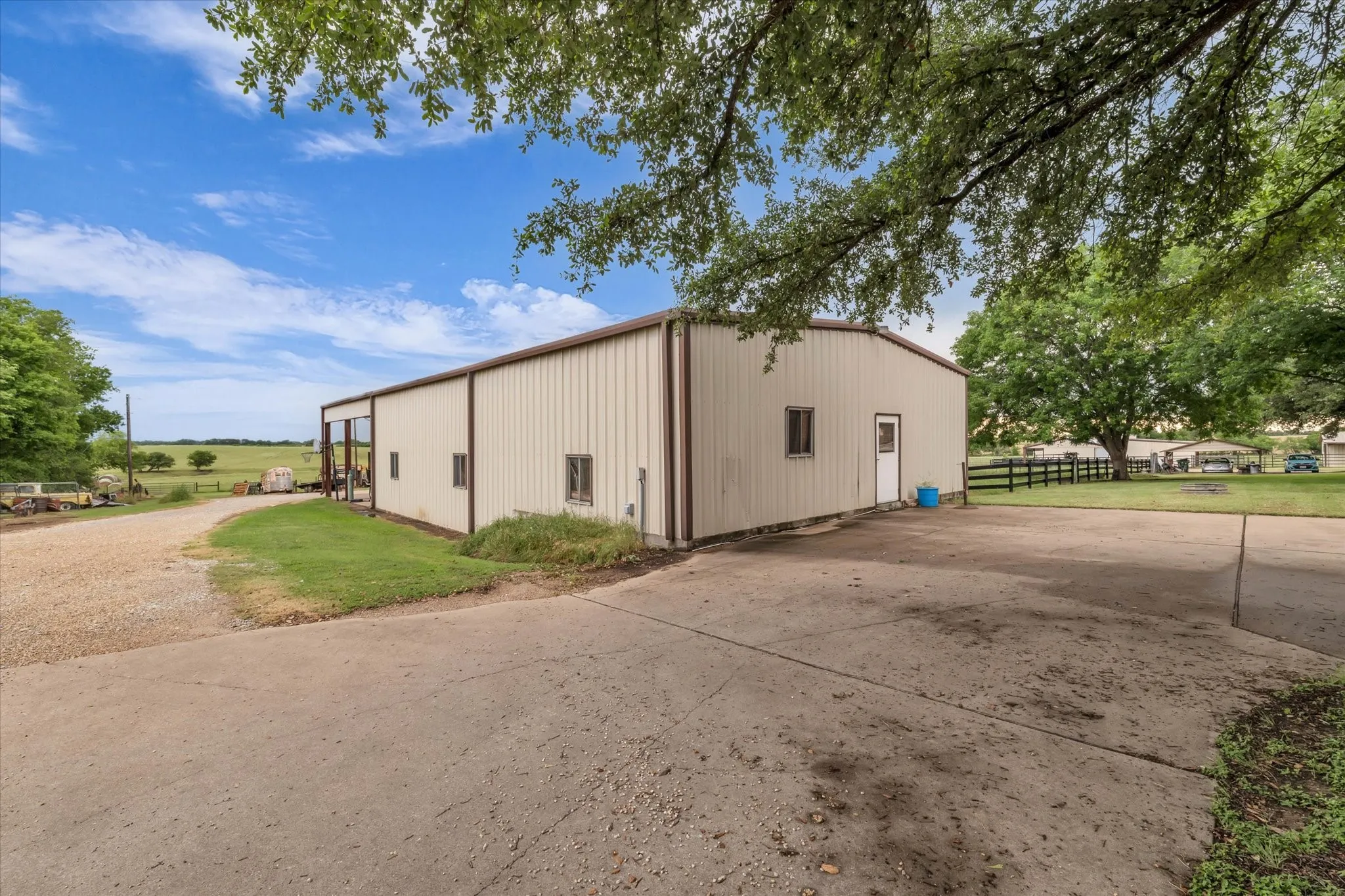 View of pole building with concrete driveway
