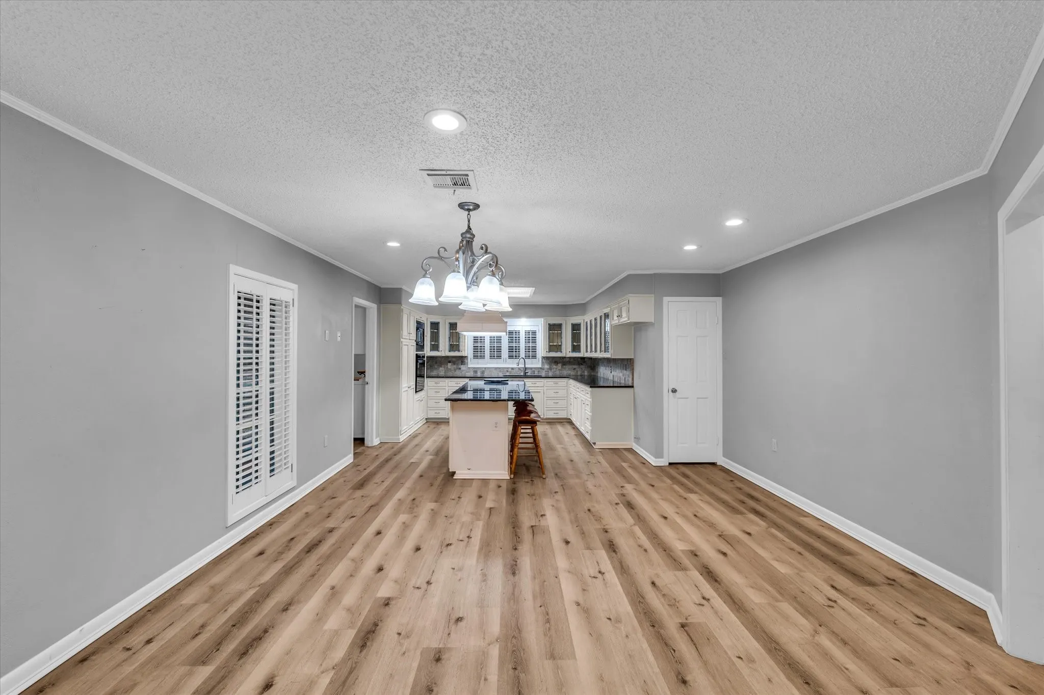 Kitchen featuring a chandelier, a textured ceiling, recessed lighting, tasteful backsplash, and crown molding