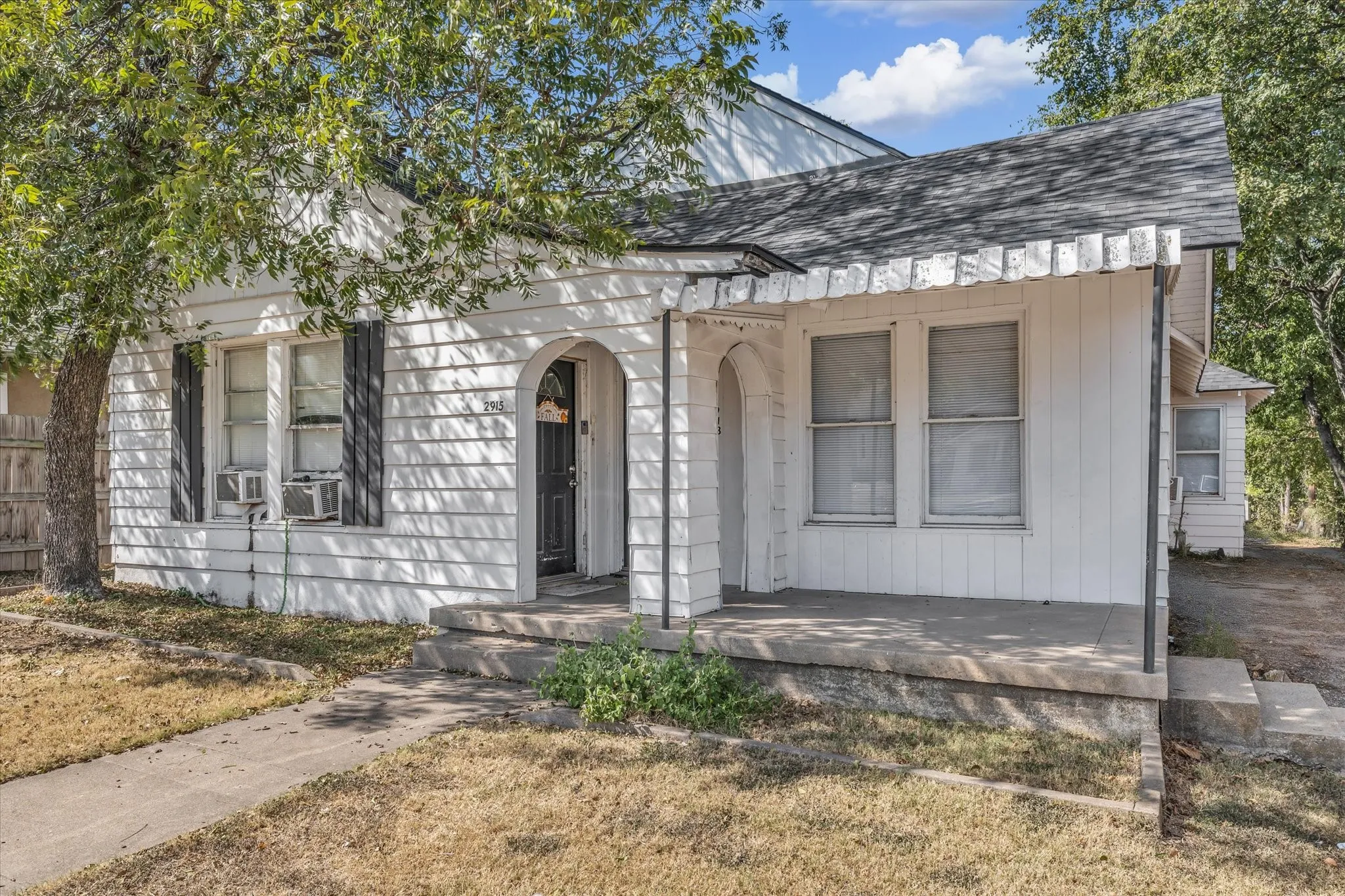 View of front of home featuring roof with shingles and covered porch
