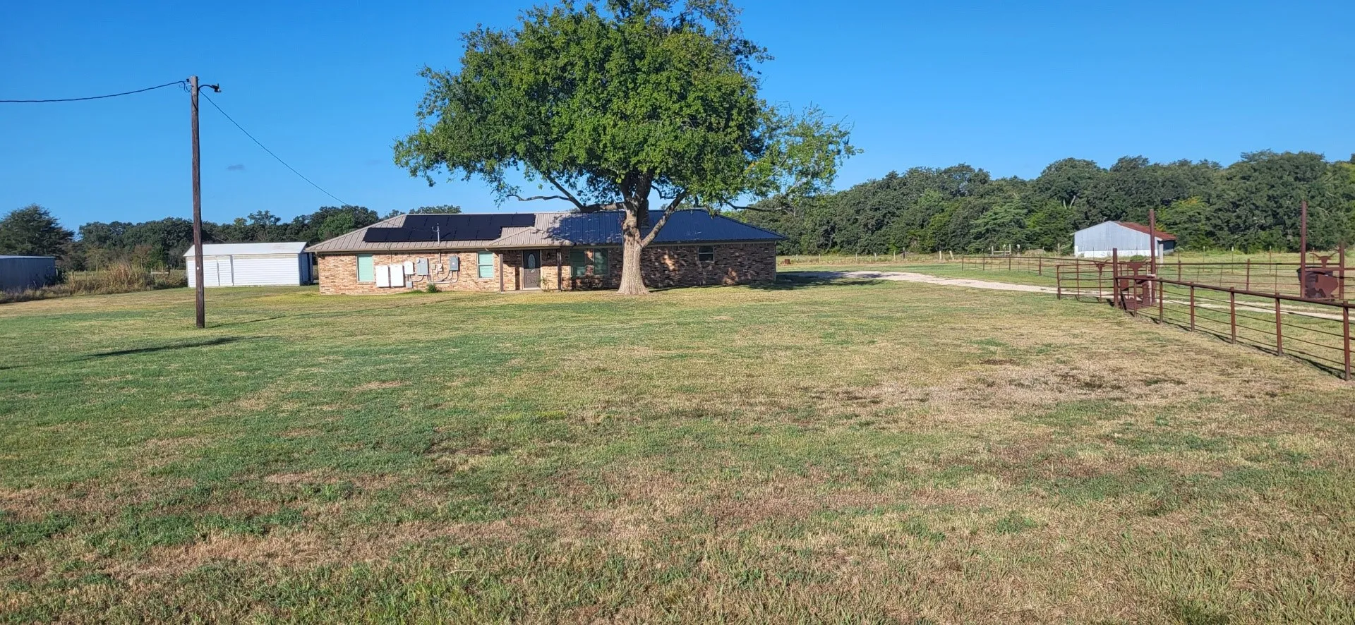 View of yard with an outdoor structure, a garage, and a rural view