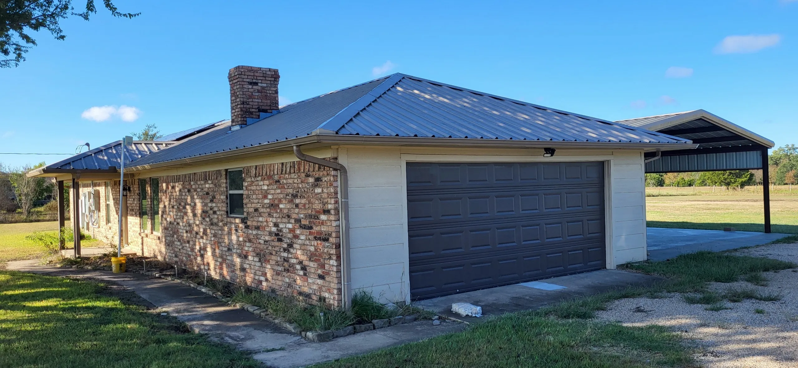 View of side of home featuring a garage and a yard
