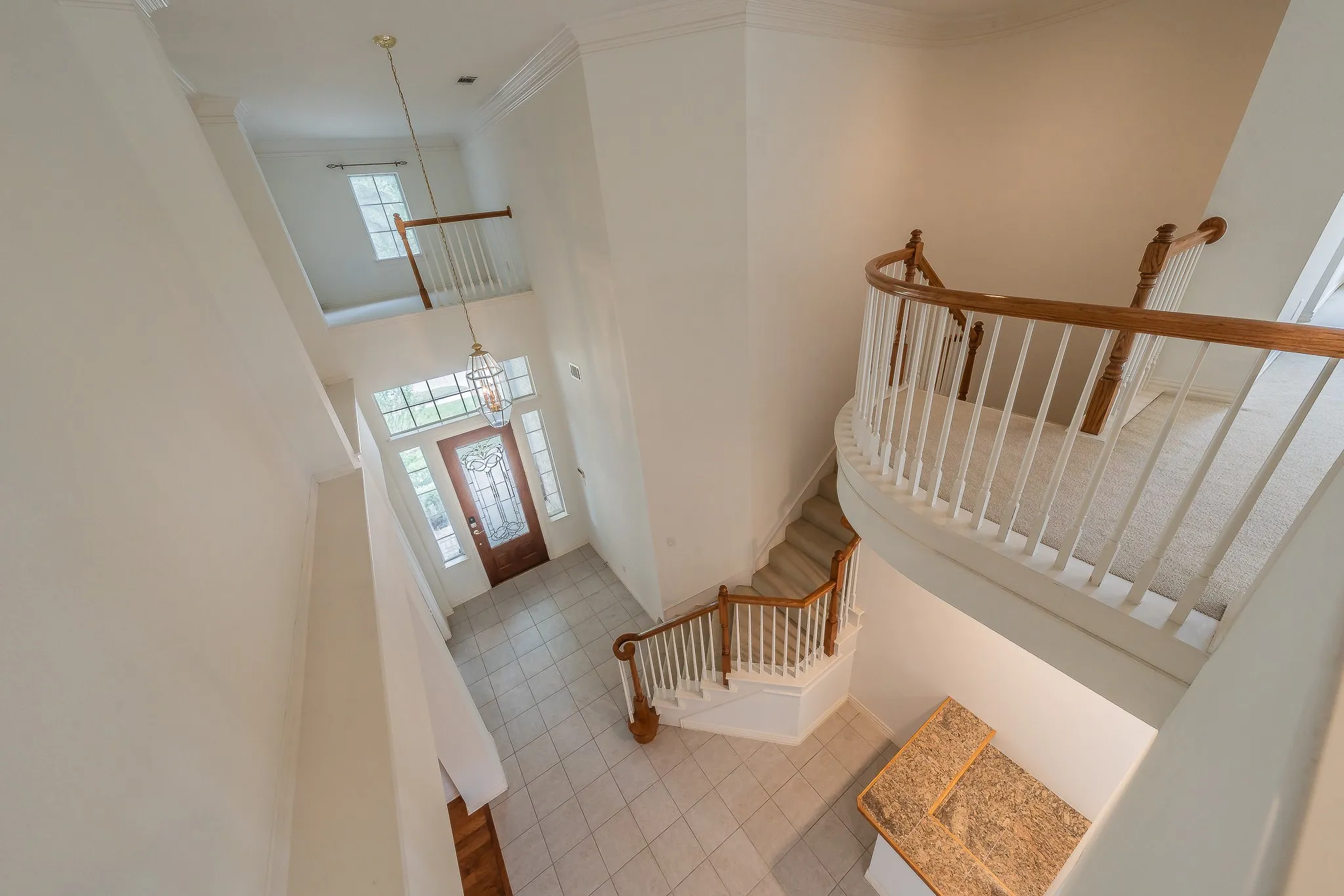 Two-story foyer featuring a decorative glass front door, transom window, and sidelights