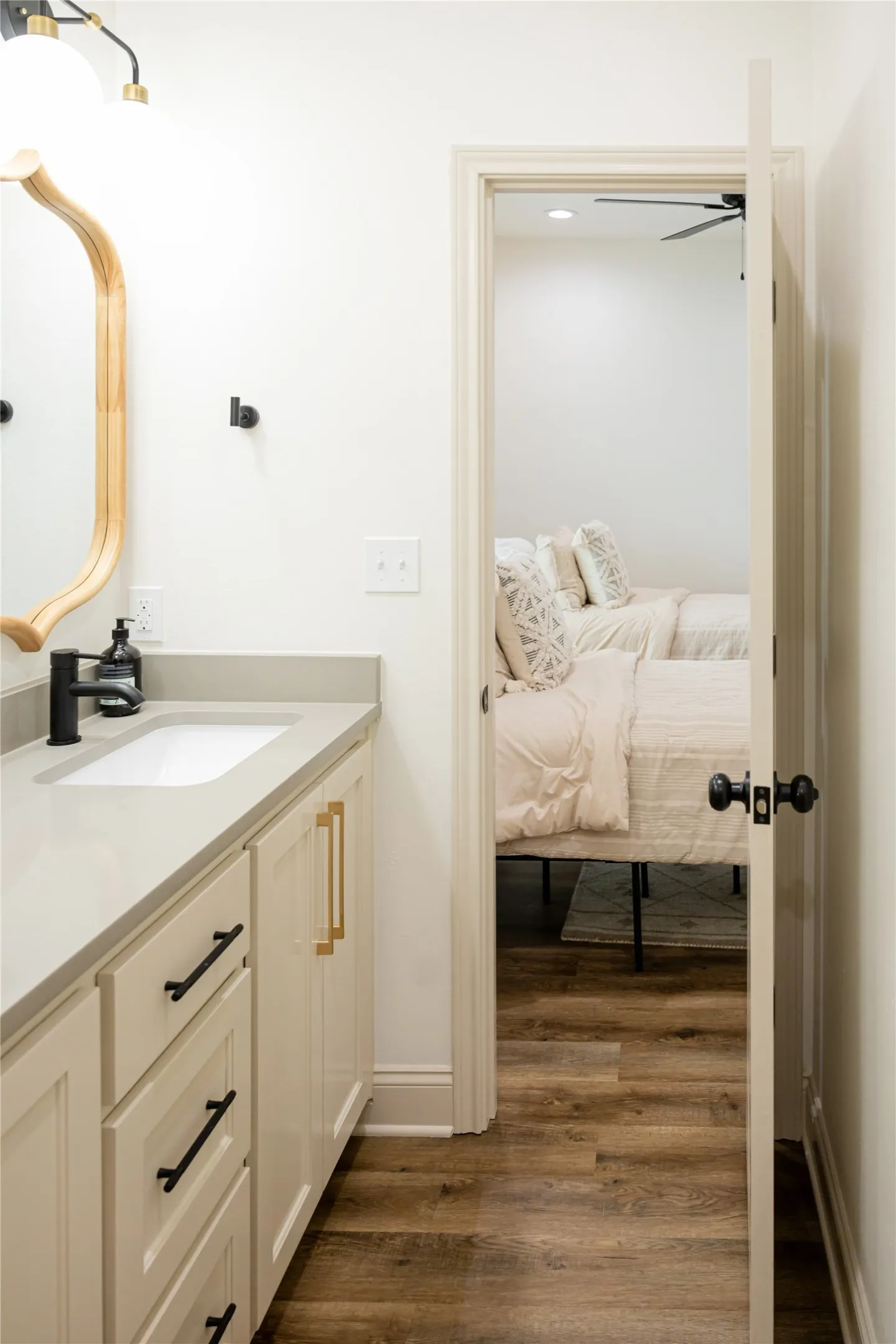 Bathroom with vanity, dark wood-style flooring, ceiling fan, and ensuite bathroom
