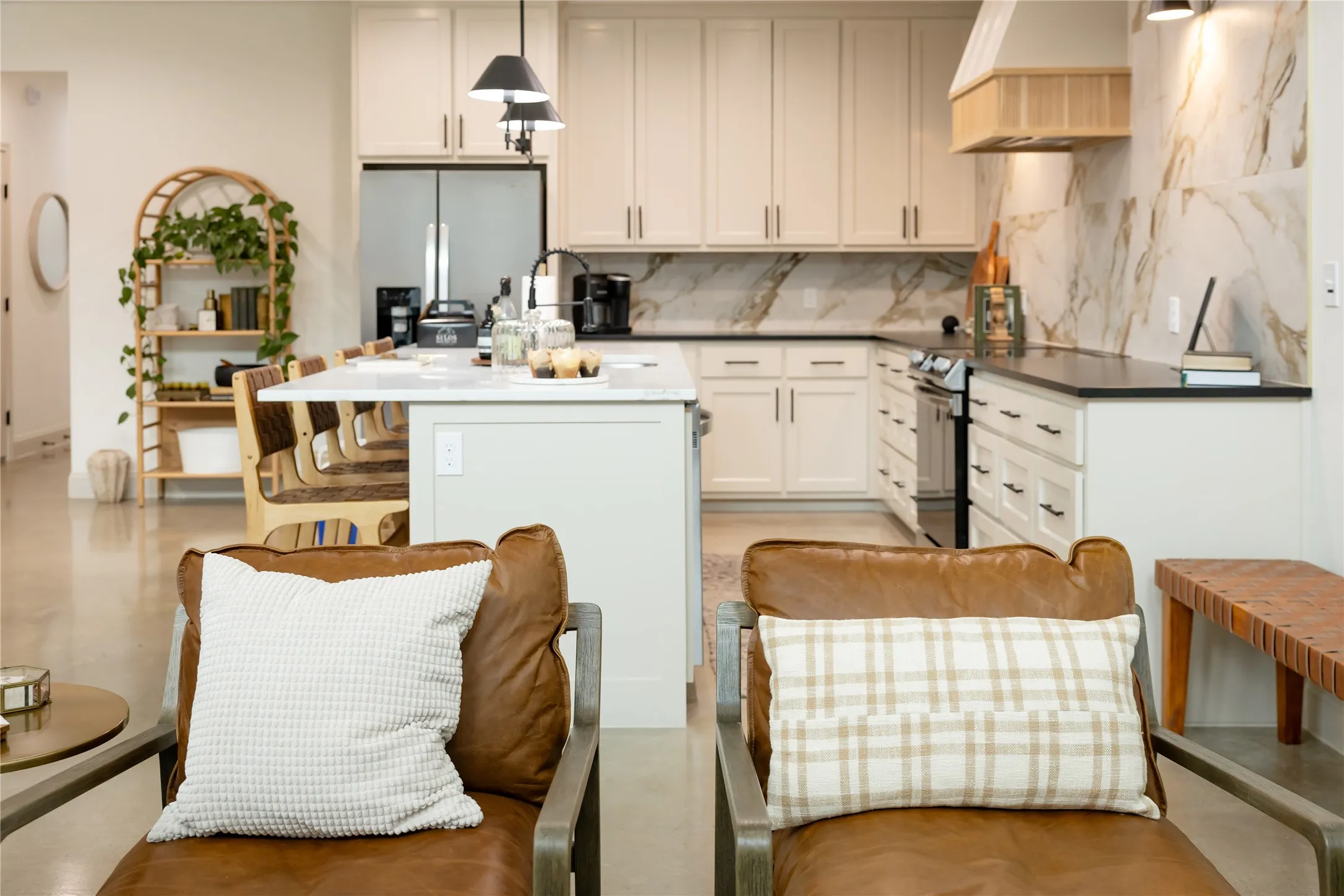 Kitchen featuring a center island, stainless steel refrigerator with ice dispenser, electric range, hanging light fixtures, and decorative backsplash