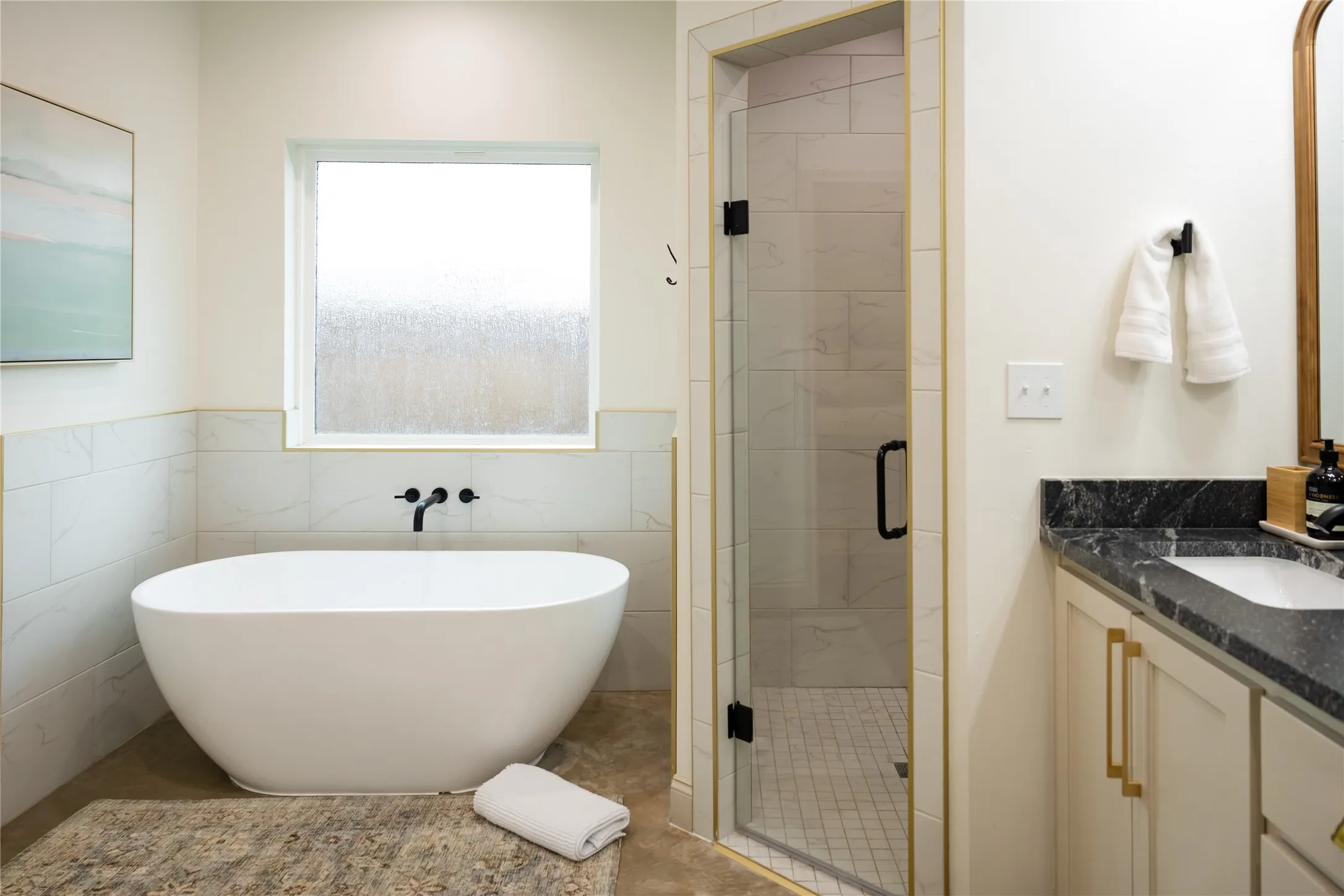 Bathroom with vanity, a shower stall, tile walls, a freestanding bath, and wainscoting